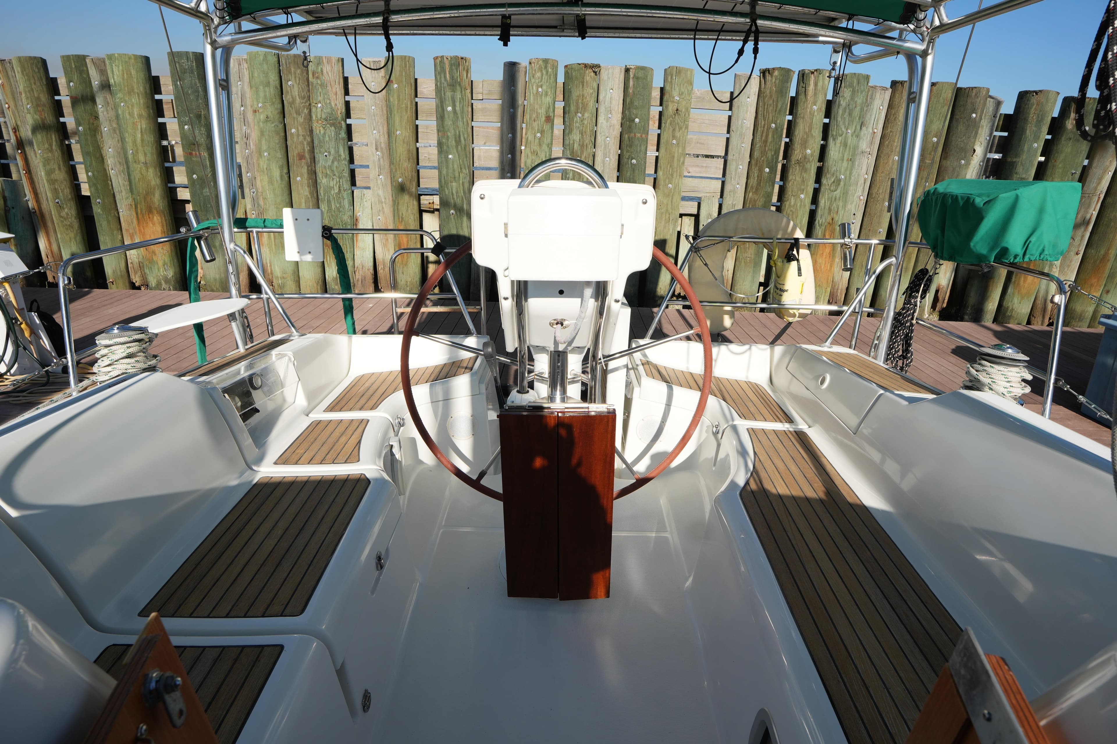Cockpit of 2007 Beneteau 373 sailboat with wooden seating and steering wheel.