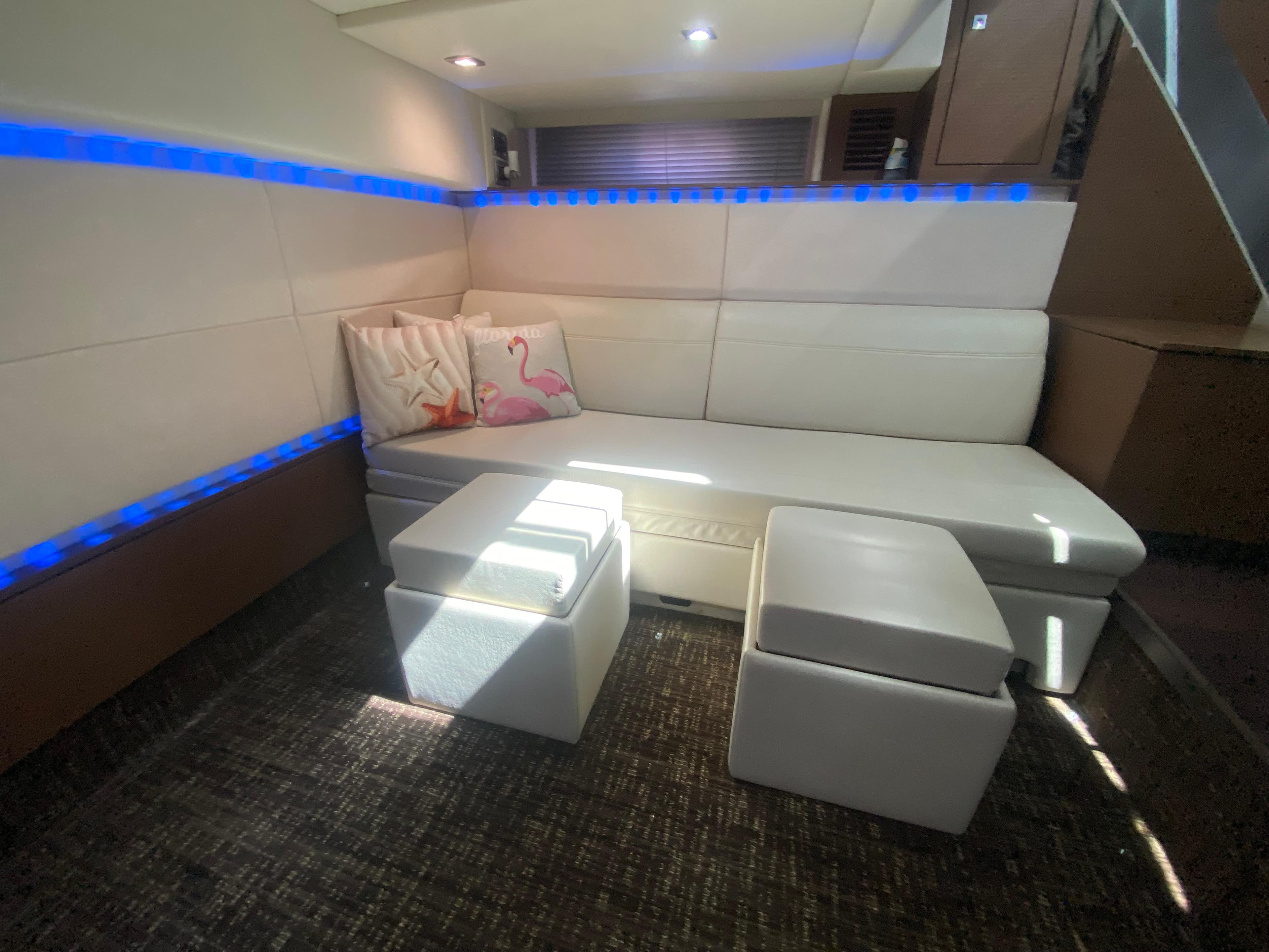 Luxurious interior of 2012 Sea Ray 450 Sundancer with white seating and ambient lighting.