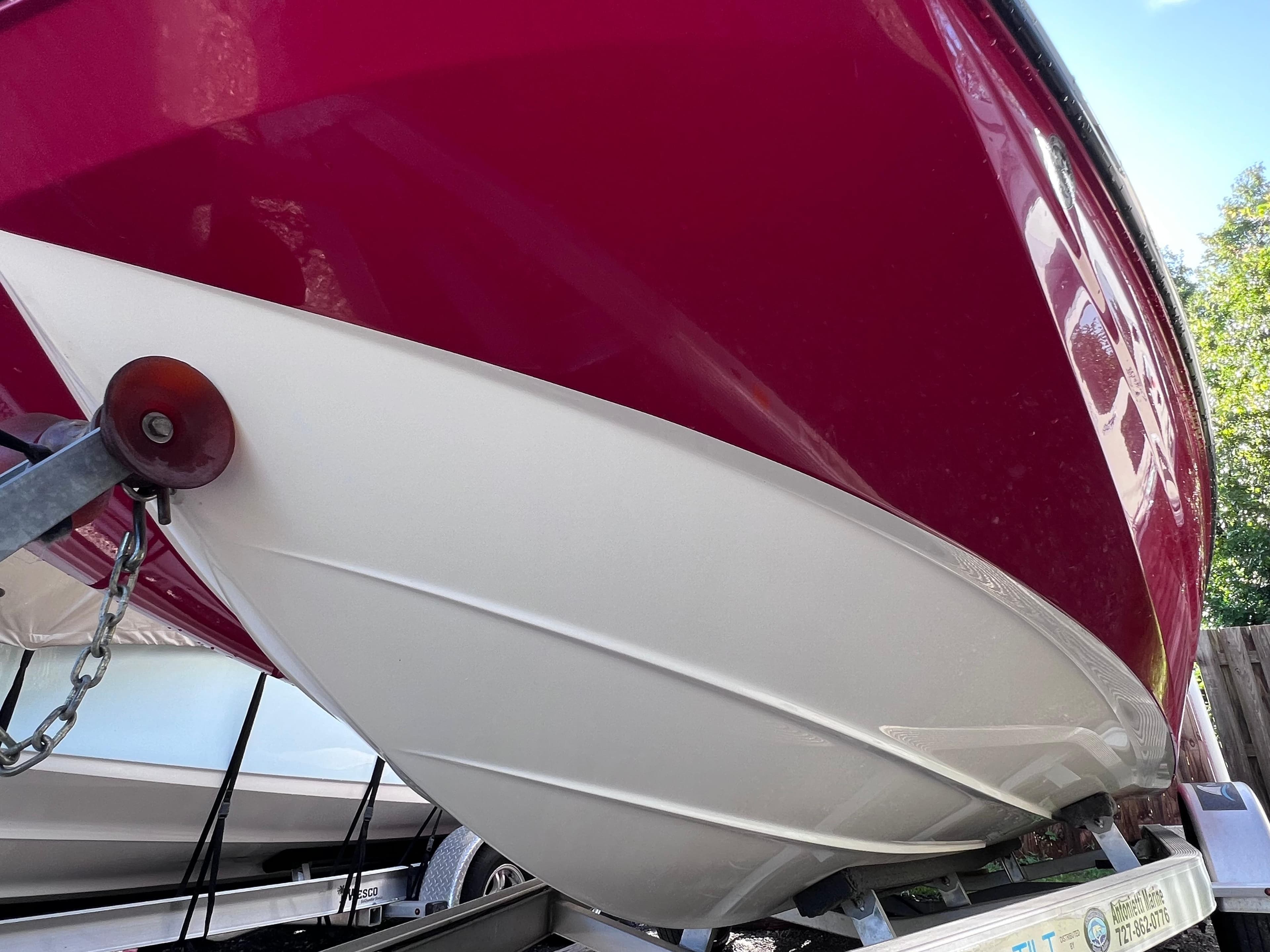 2016 Bayliner 195 Deck Boat on trailer, red and white hull close-up.