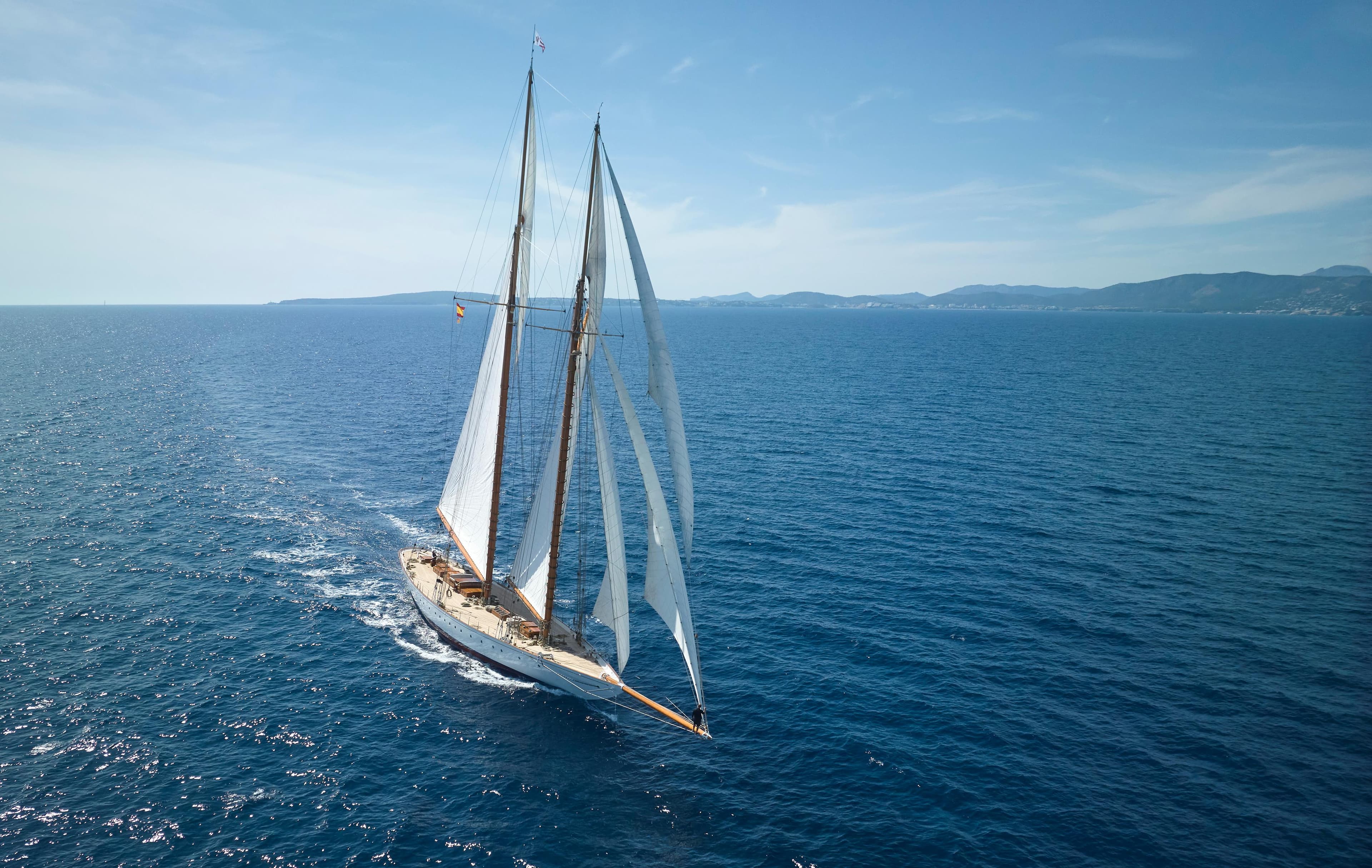 Sailing yacht by Factoria Naval de Marin, 2009, cruising on open sea under clear skies.
