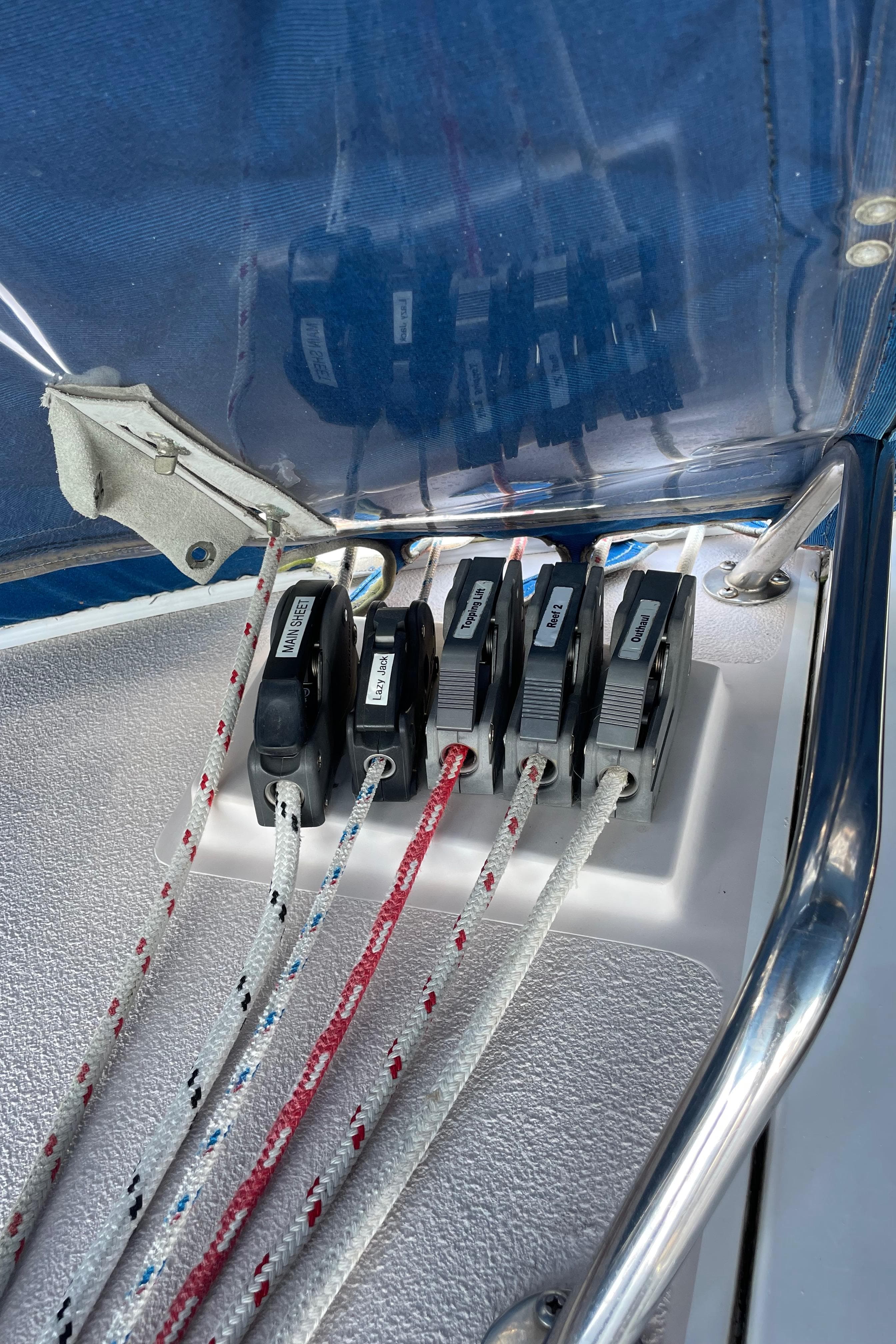 Close-up of Catalina 400 sailboat rope clutches, 1998 model, with colorful ropes and metal railing.