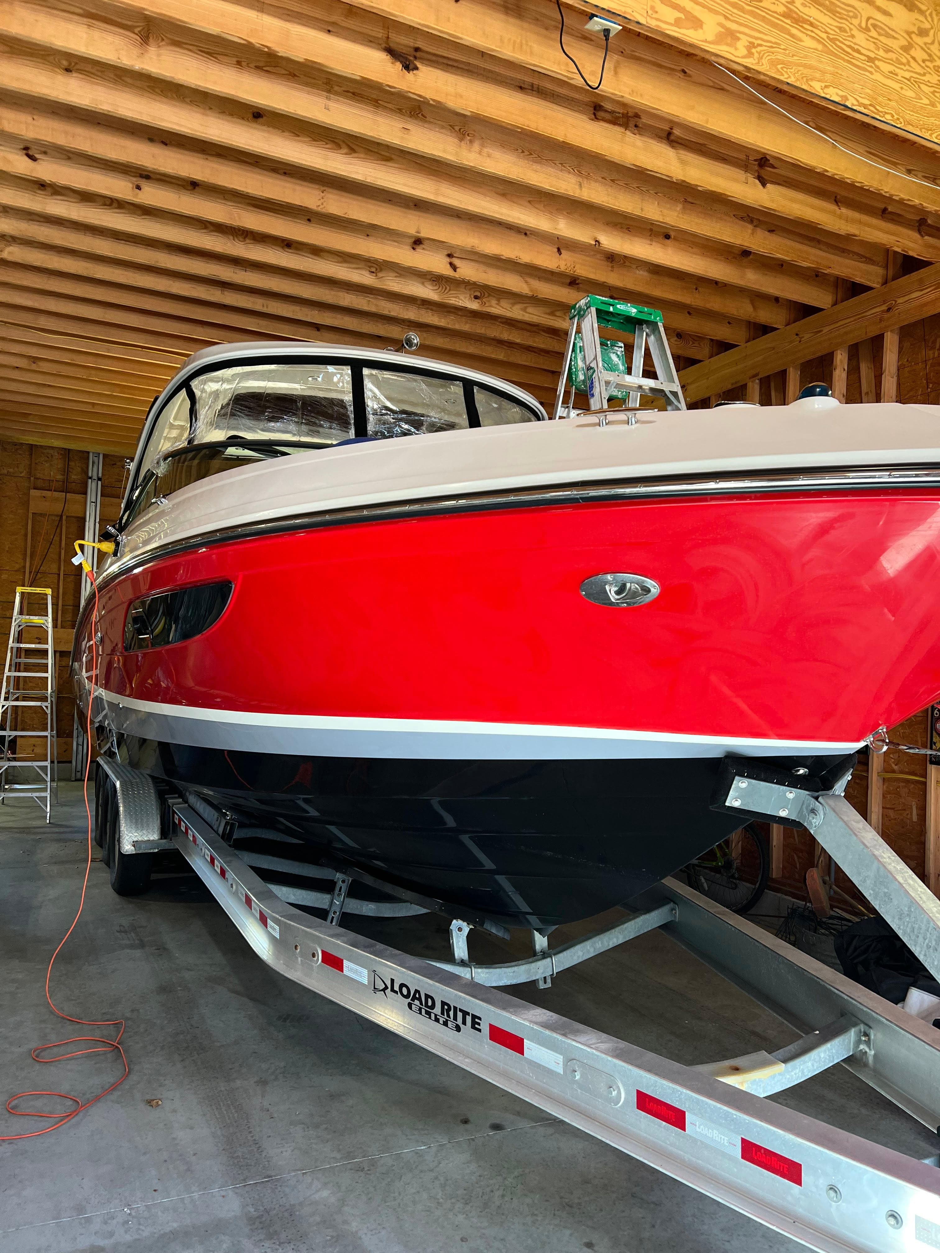 2017 Sea Ray 350 SLX boat in storage, vibrant red hull, on a trailer.
