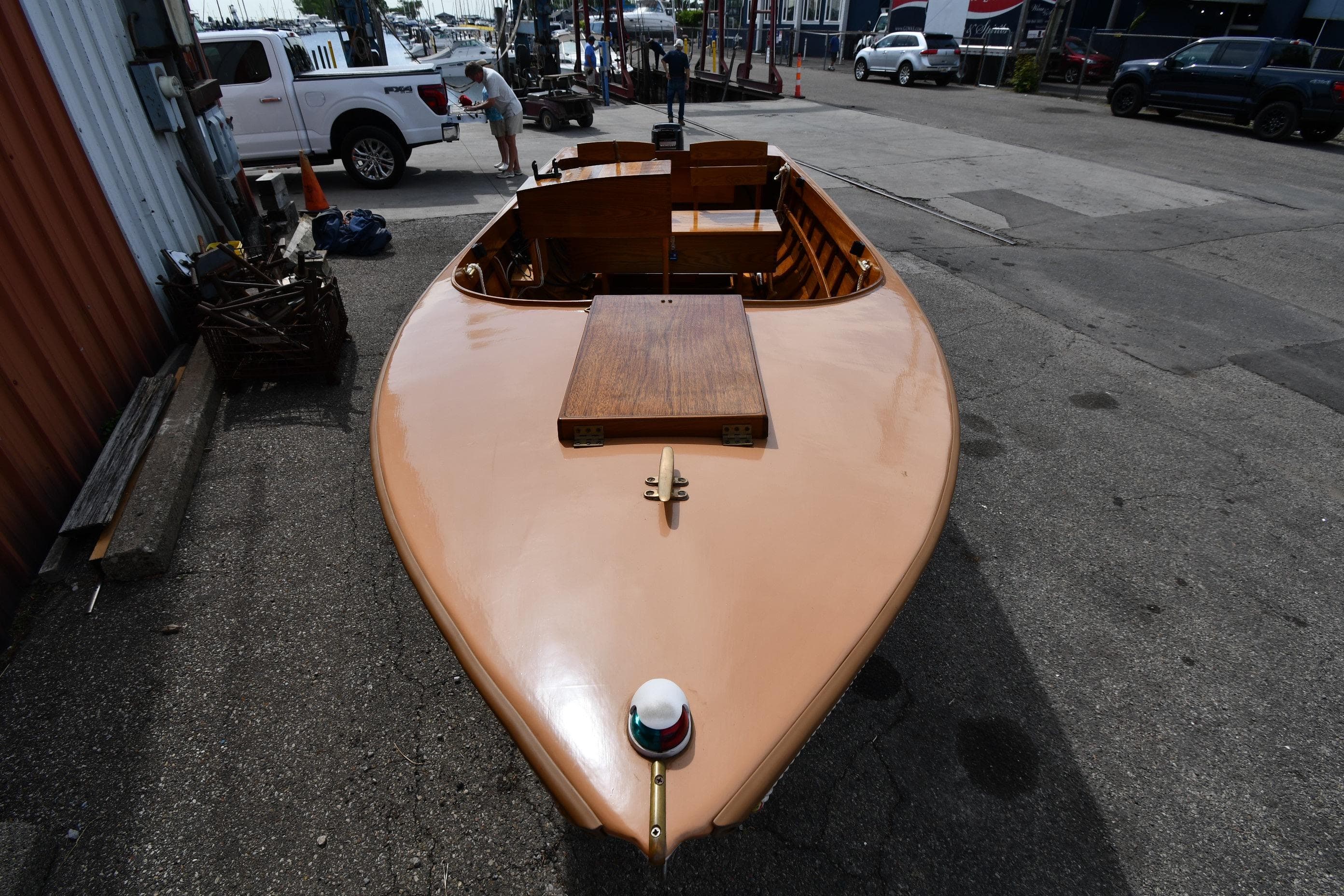 2003 Great Lakes 16 Skiff boat on pavement, showcasing sleek wooden design.