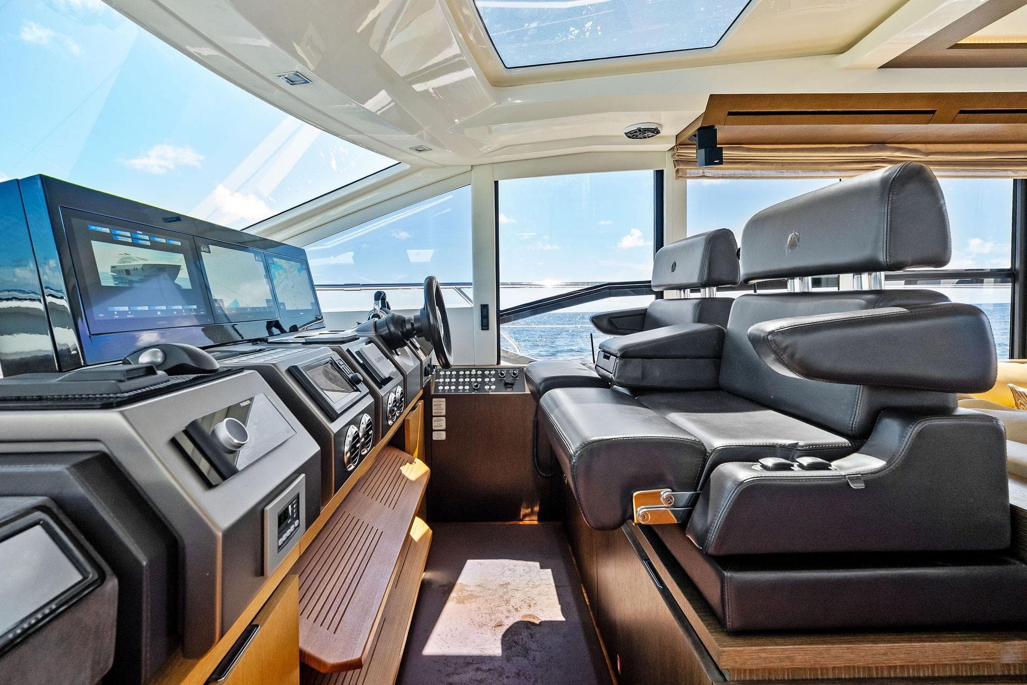 Luxurious interior of a 2013 Absolute 64 yacht with modern navigation equipment and leather seating.