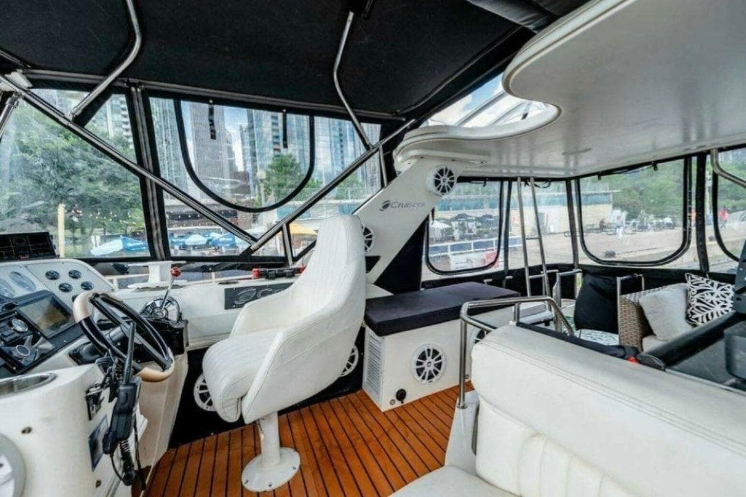 1991 Cruisers Yachts 3850 Aft Cabin interior with helm, seating, and cityscape view.