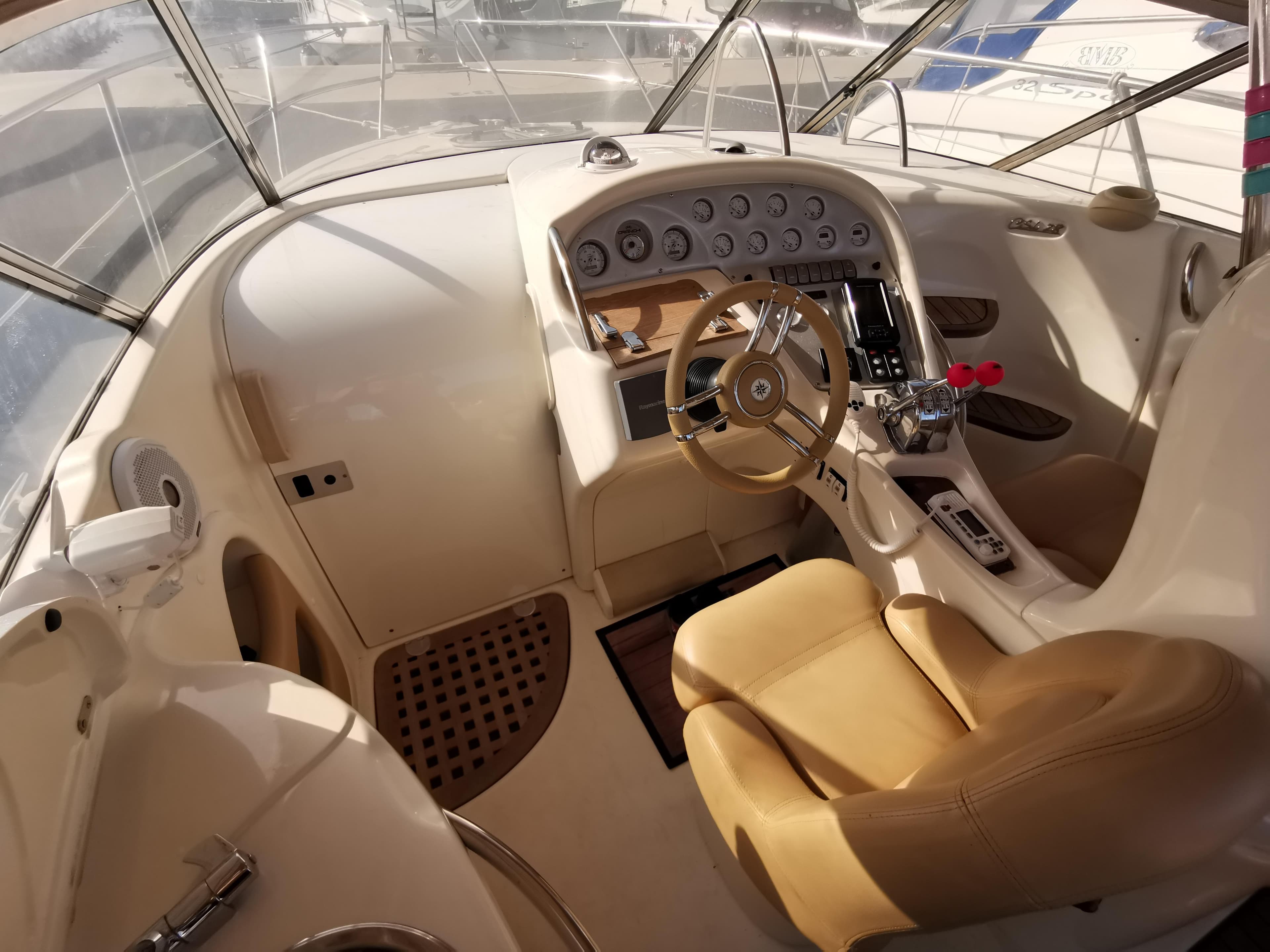Interior of 1999 Cranchi CSL 28 boat with beige seating and control panel.