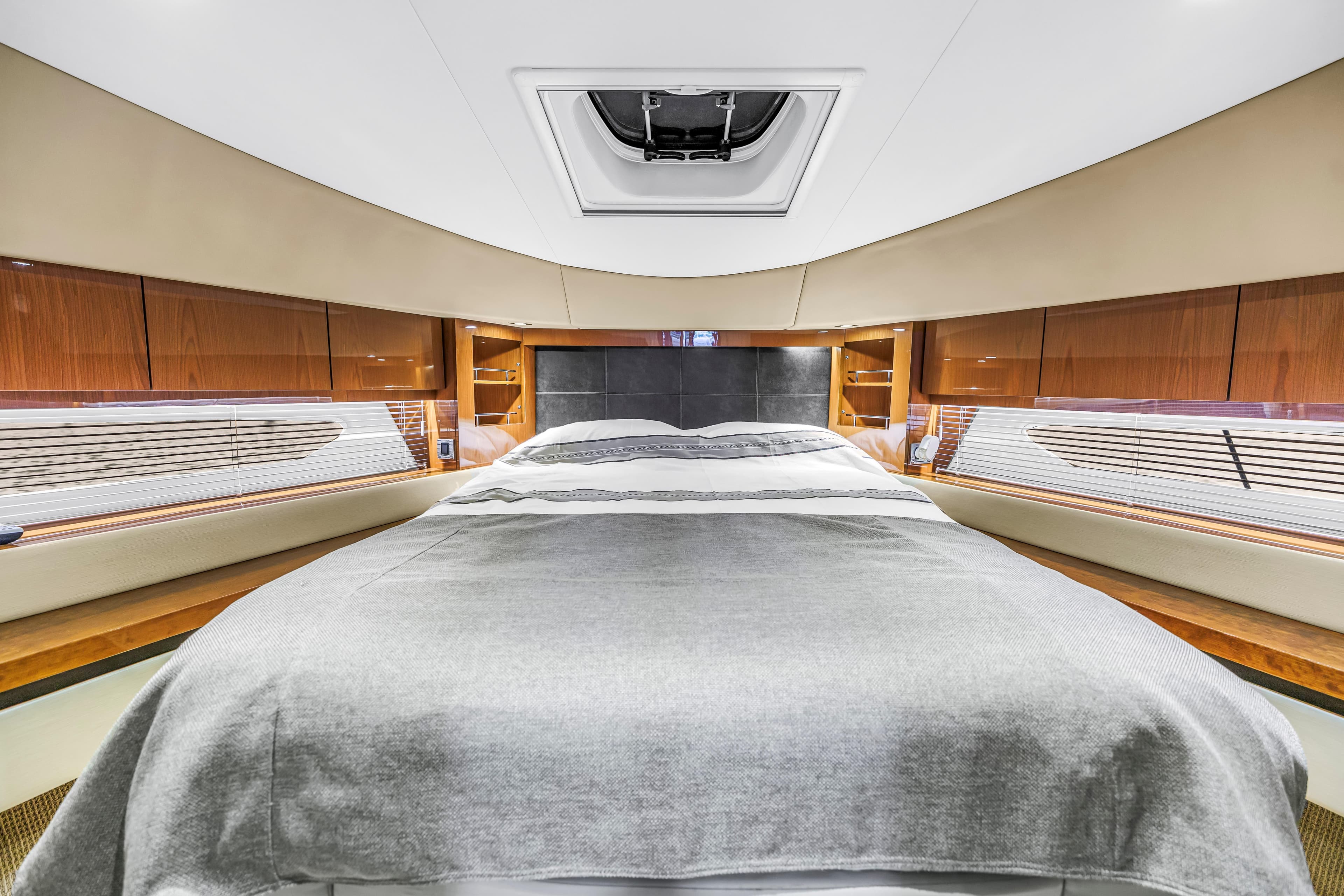 Luxurious bedroom interior of 2016 Sea Ray 510 Fly yacht with elegant wood finishes.