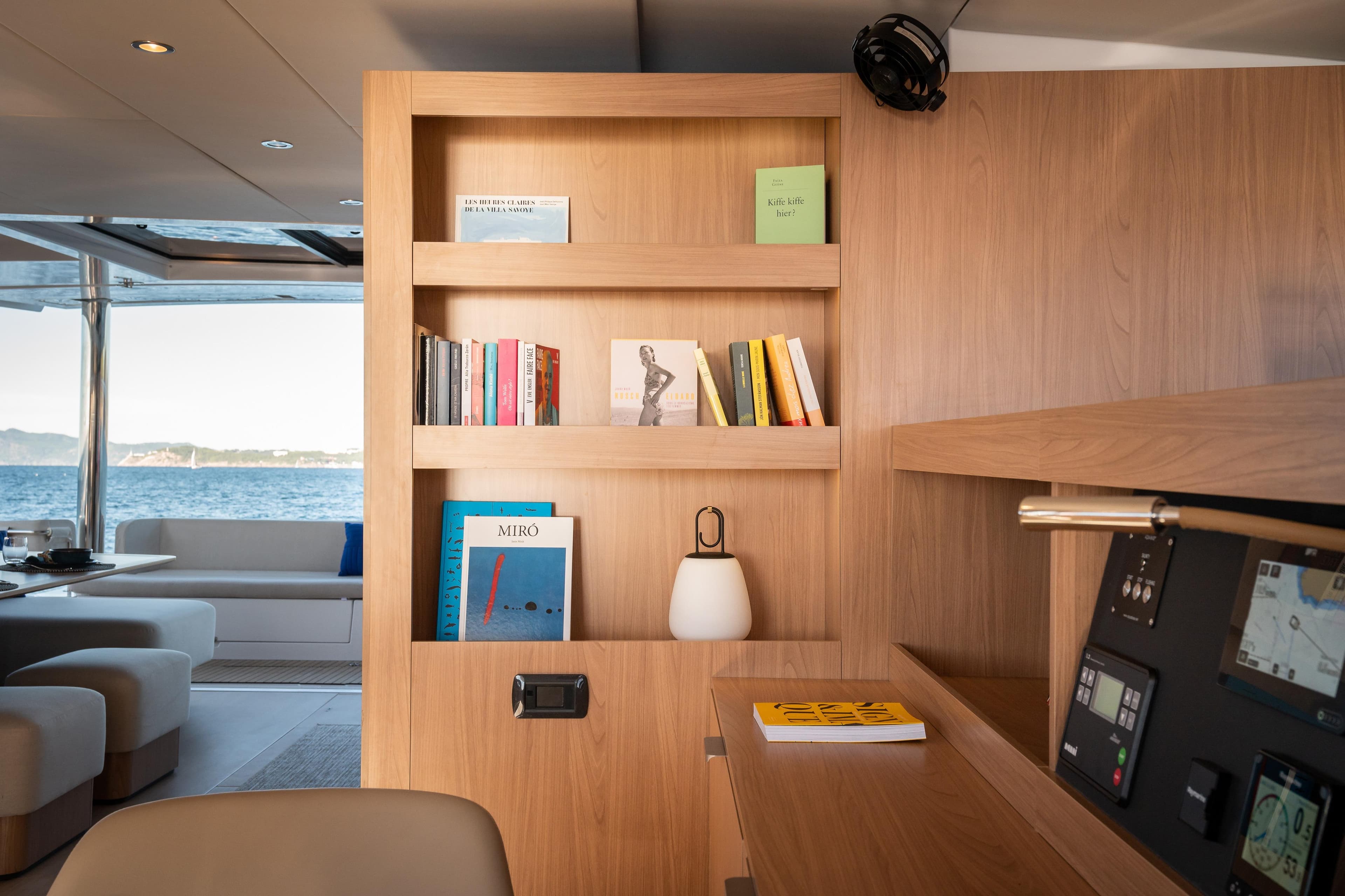 Luxurious Bali 5.8 yacht interior with wooden bookshelf, modern decor, and ocean view, 2026 model.