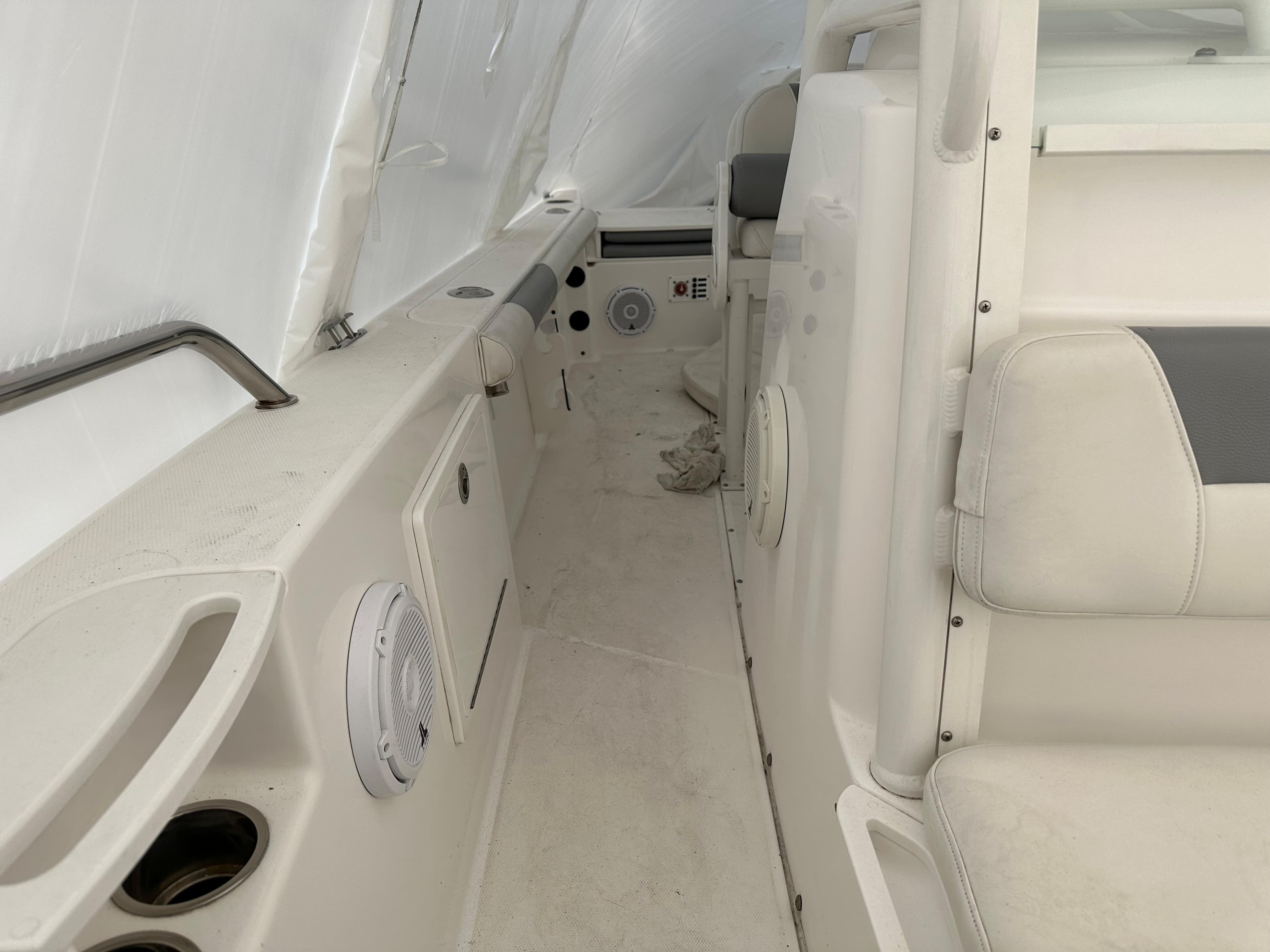 Interior view of 2018 Everglades 230CC boat, featuring white seating and built-in speakers.