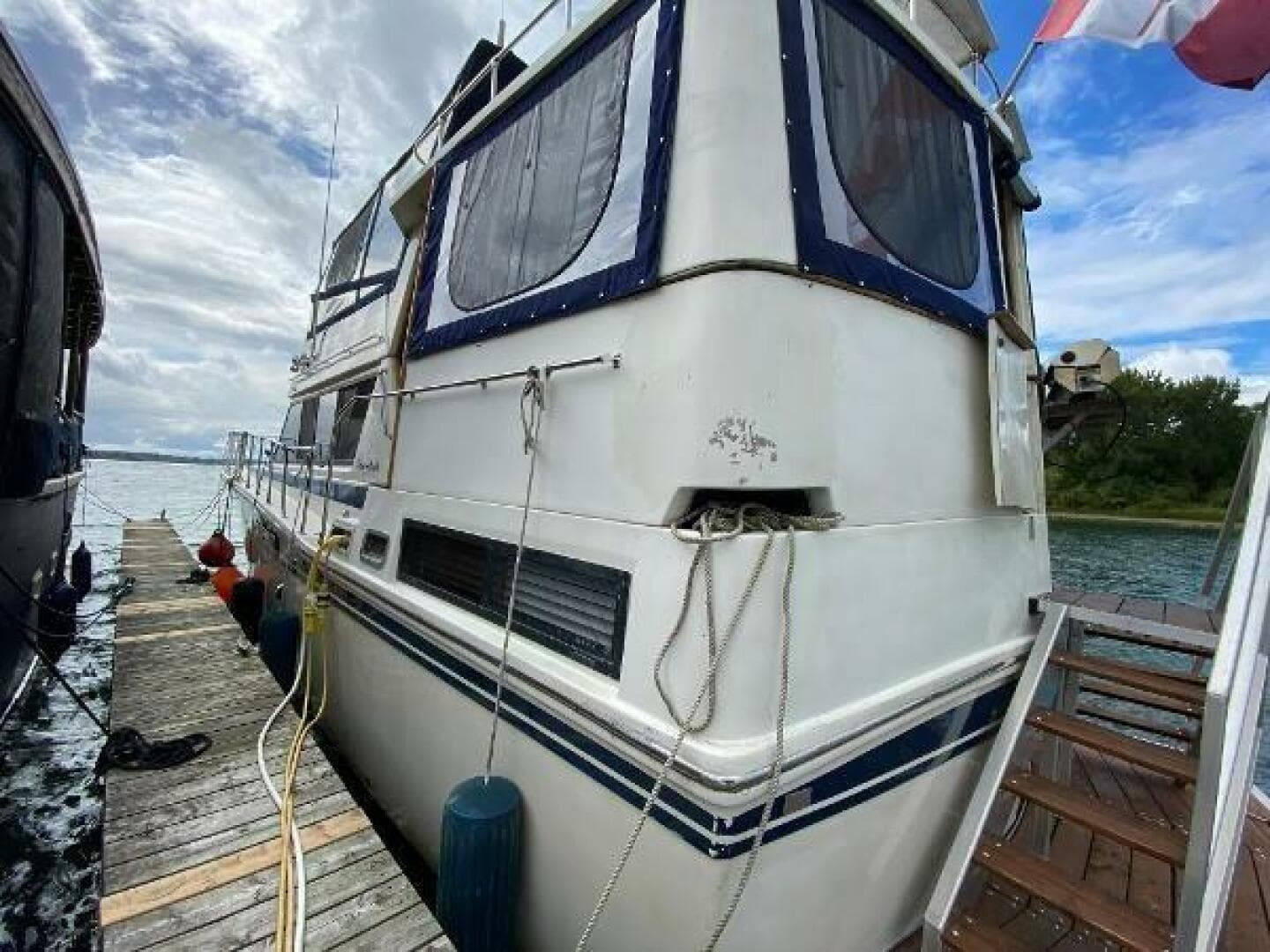 1984 Burns Craft 48 MY yacht docked, featuring a white exterior and blue accents.