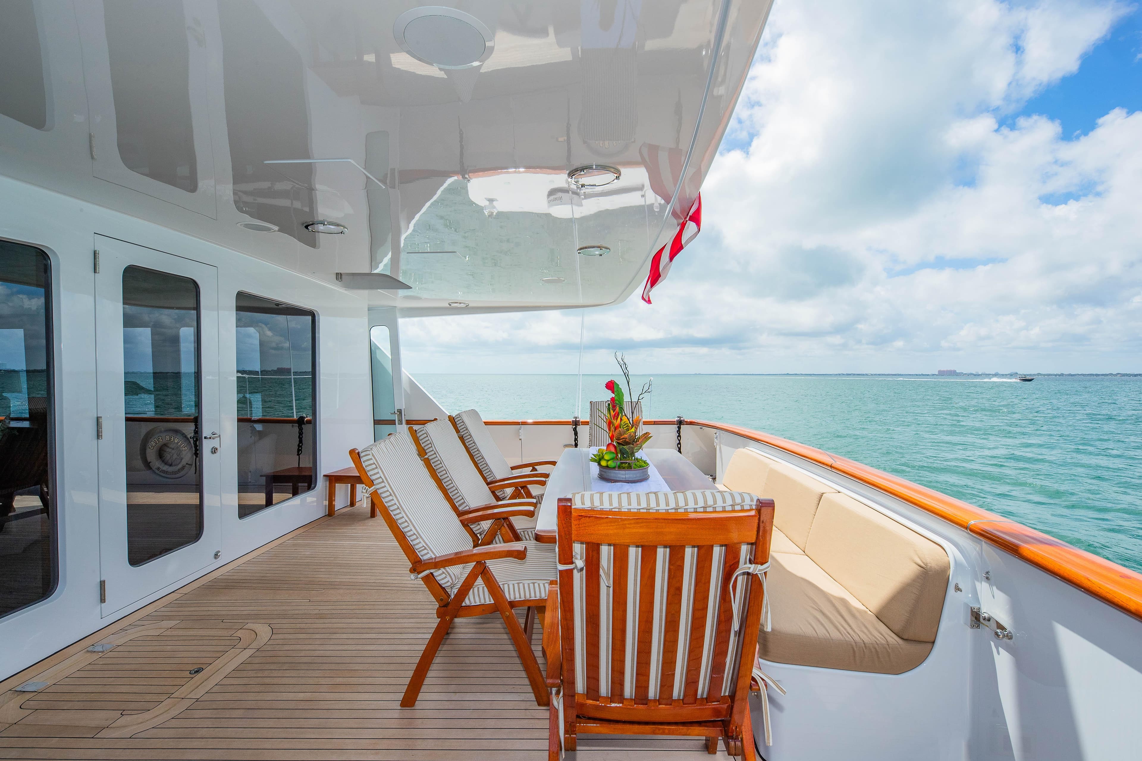 Luxurious deck of 1998 Burger Raised Pilothouse yacht with ocean view and elegant seating.