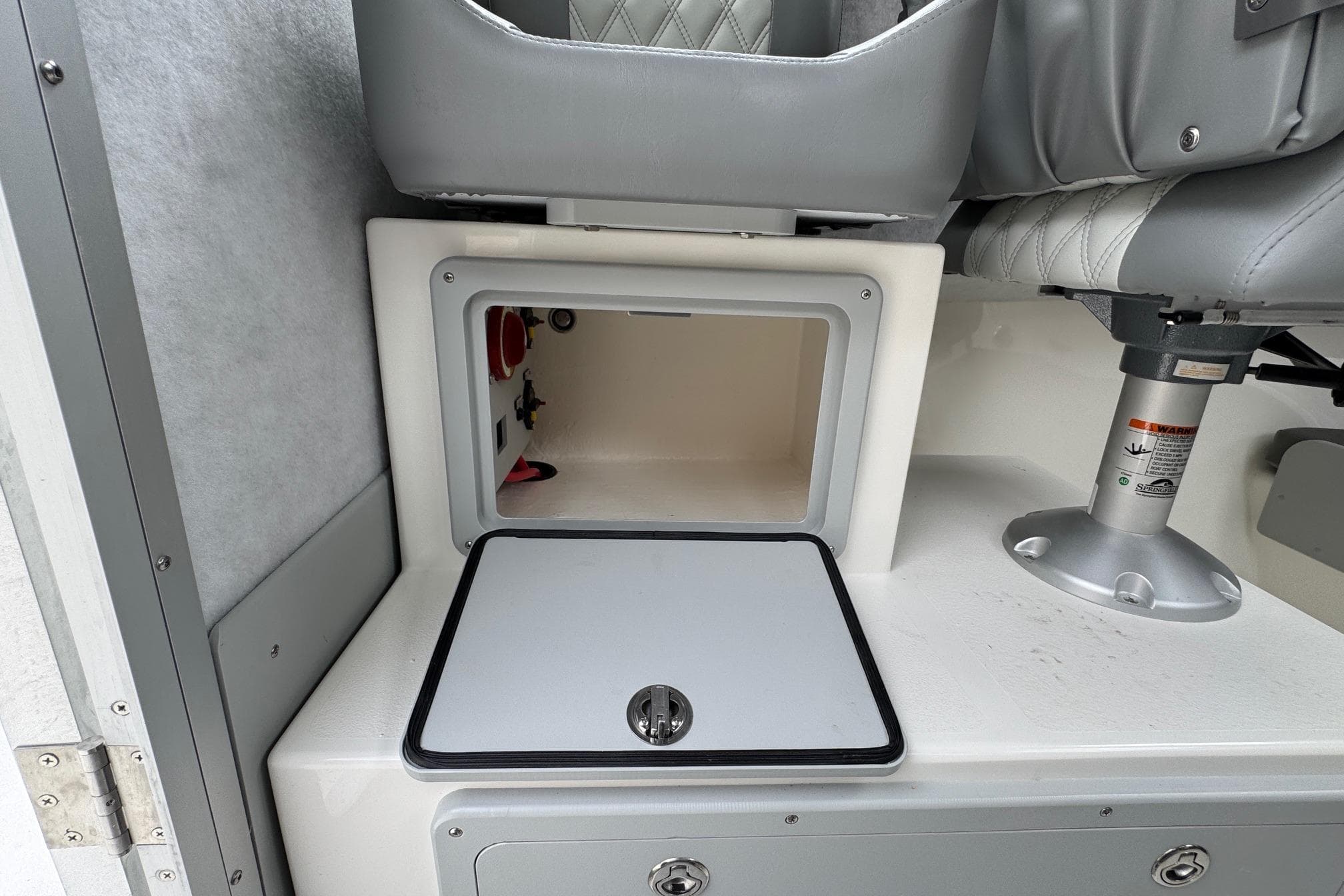 Open storage compartment in 2026 Defiance Admiral 220 EX boat interior.