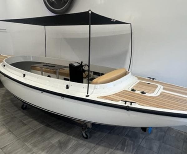 2024 Vision Marine Technologies Fantail 217 boat with canopy, displayed indoors.