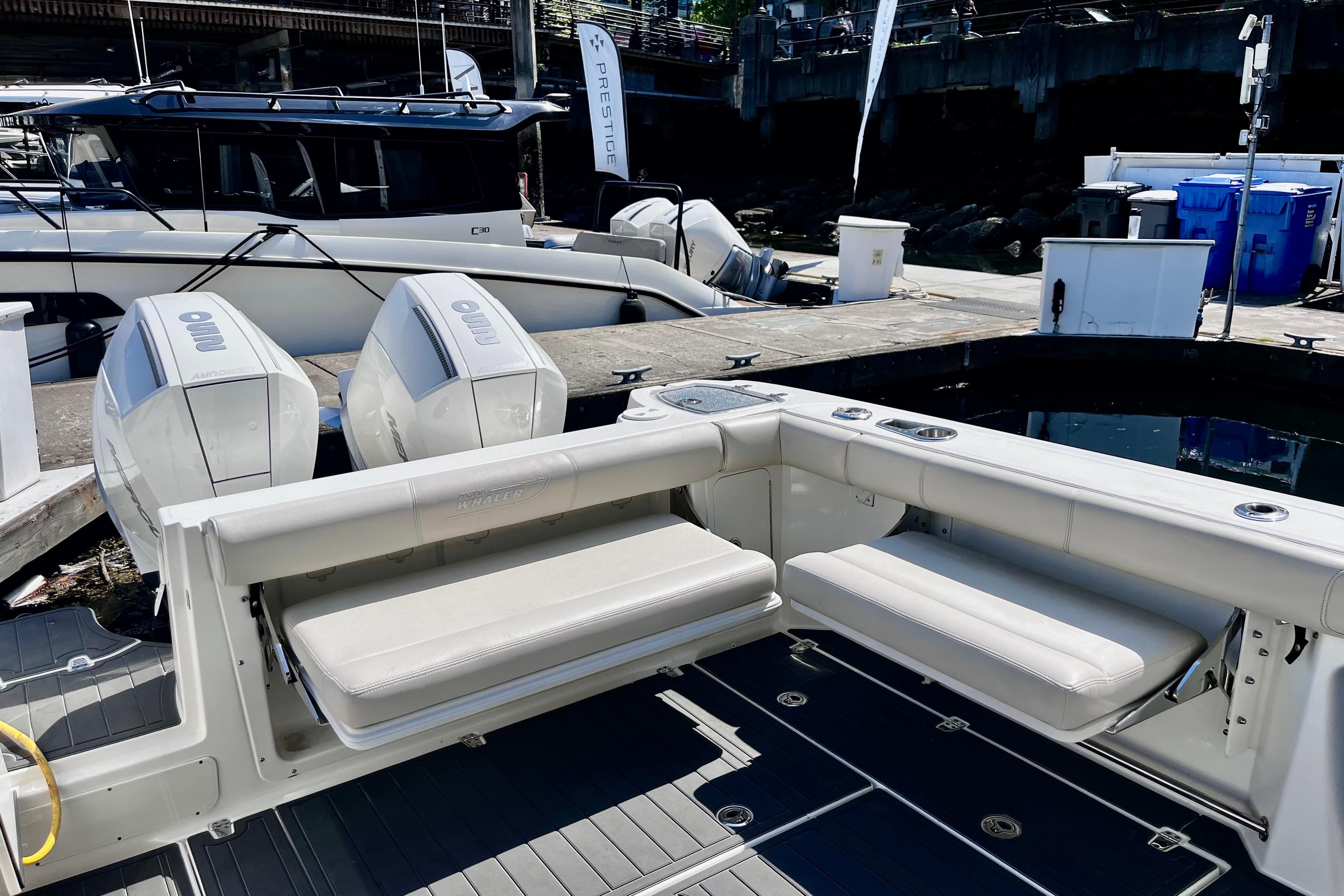 2023 Boston Whaler 285 Conquest boat with dual outboard engines at a marina.