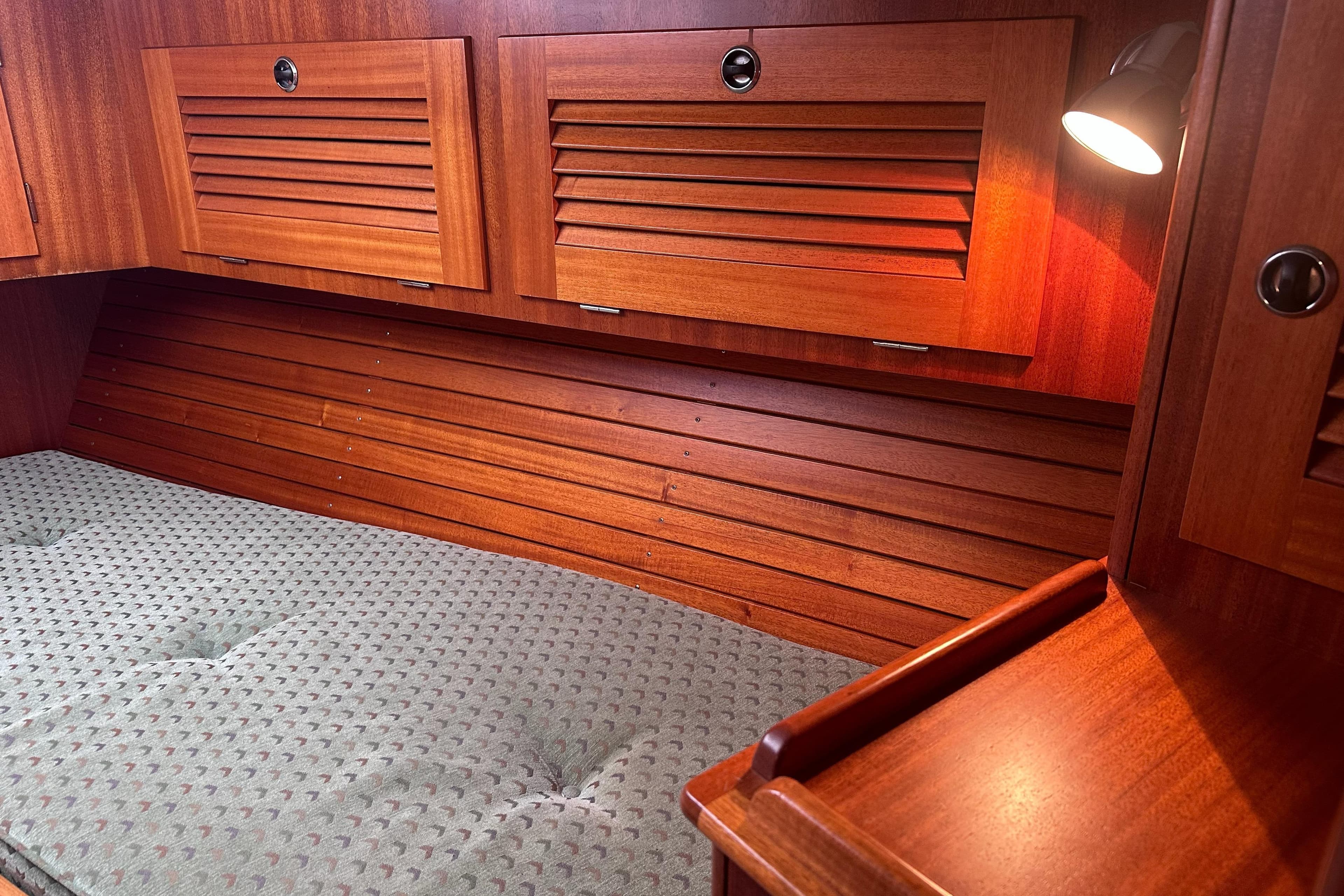Interior cabin of 2000 Hallberg-Rassy 46 yacht with wooden finish and cozy lighting.