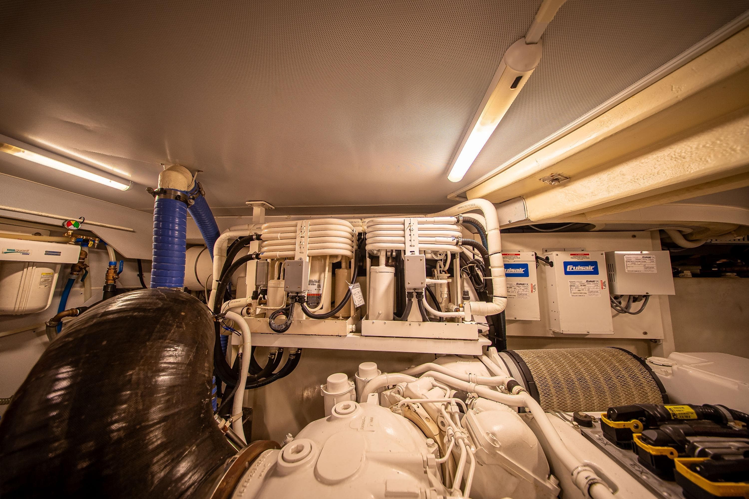 Engine room of a 2012 Marquis 690 yacht, featuring mechanical components and wiring.