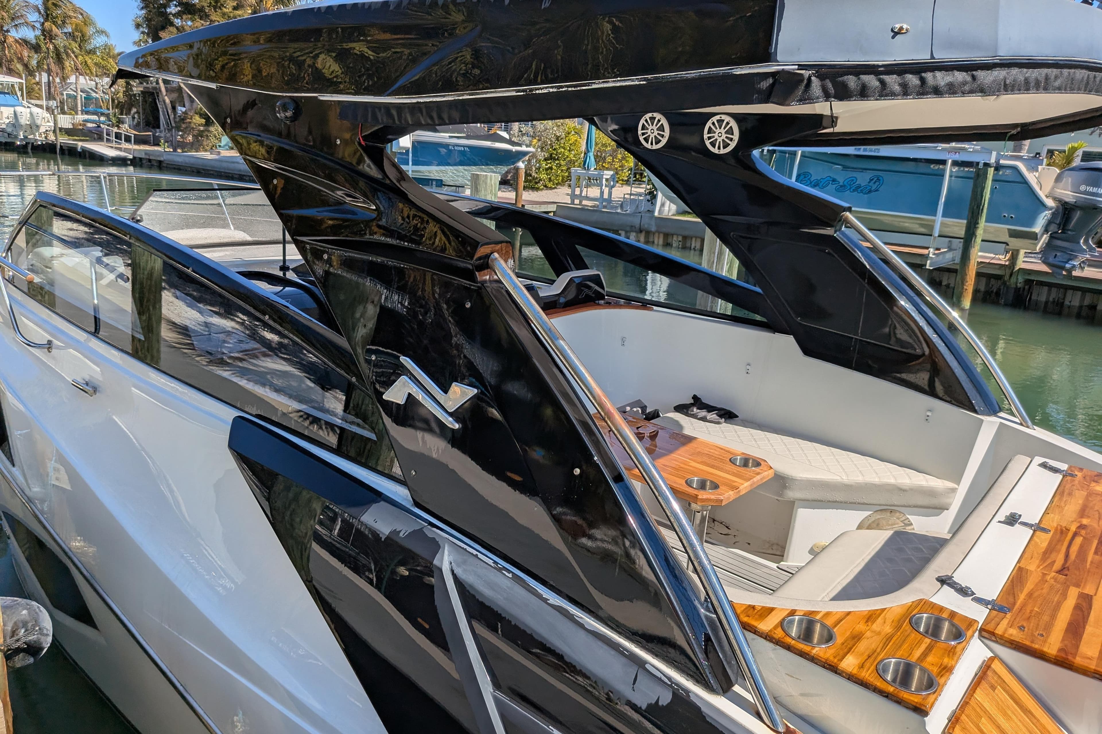 2023 NX Boats 340 Sport Coupe, sleek design, luxurious interior, docked at marina.