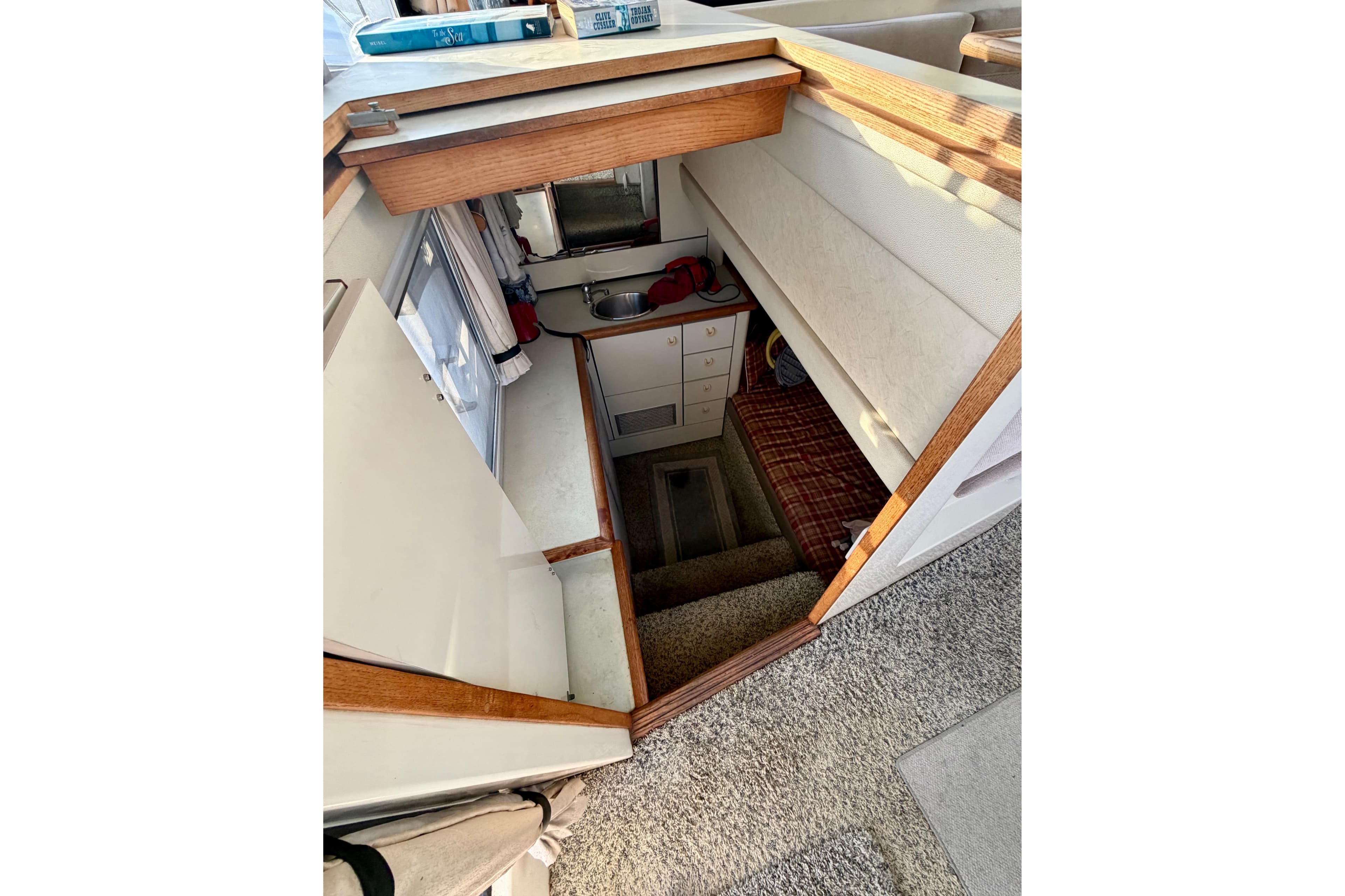 Interior view of 1993 Bayliner 3688 Motoryacht, featuring compact kitchen and cozy seating area.