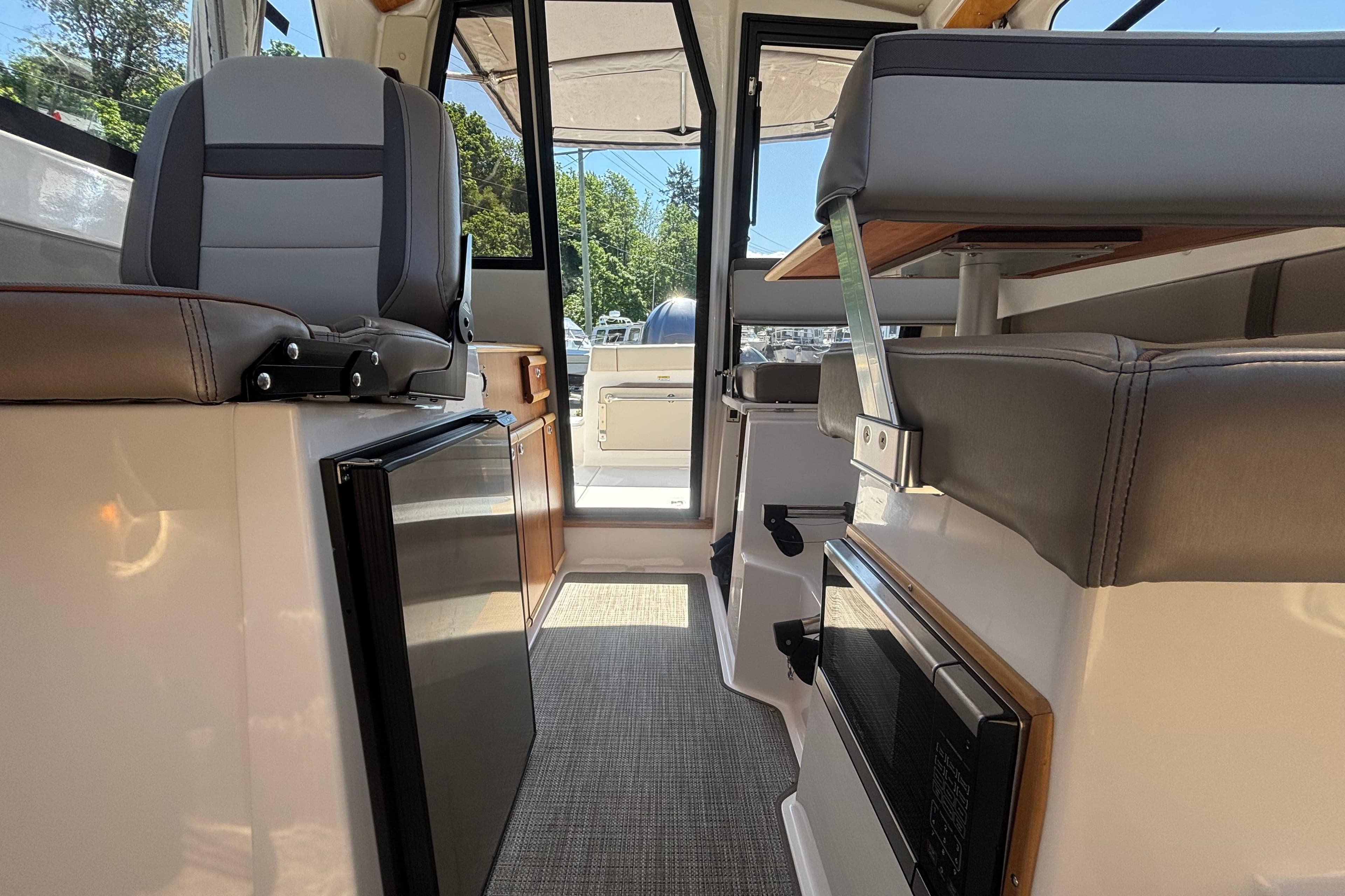 Interior of 2021 Cutwater C-242 Coupe boat, featuring seating and compact kitchen area.