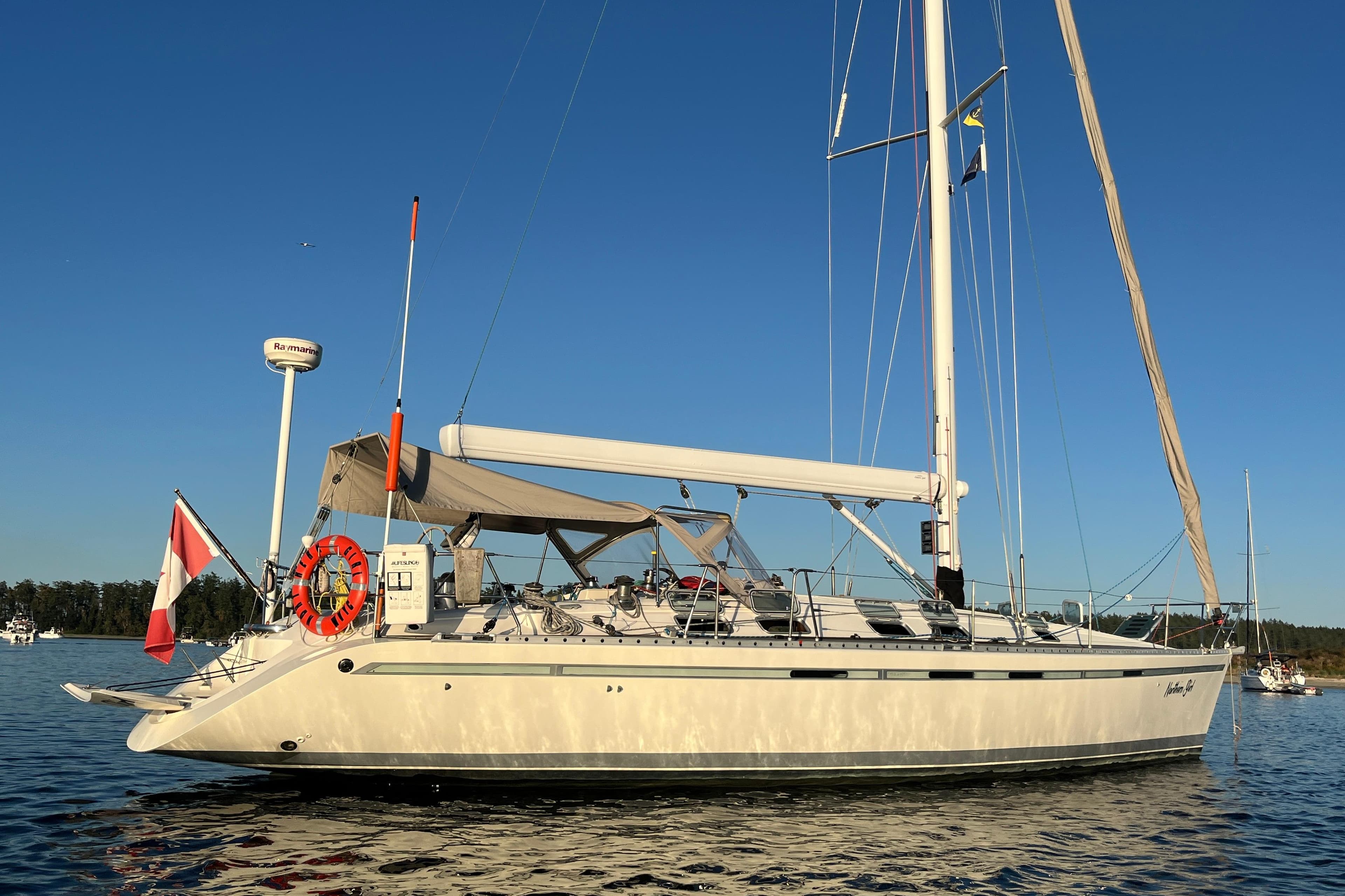Sailing yacht Beneteau First 45f5, 1991 model, anchored on calm water under clear blue sky.