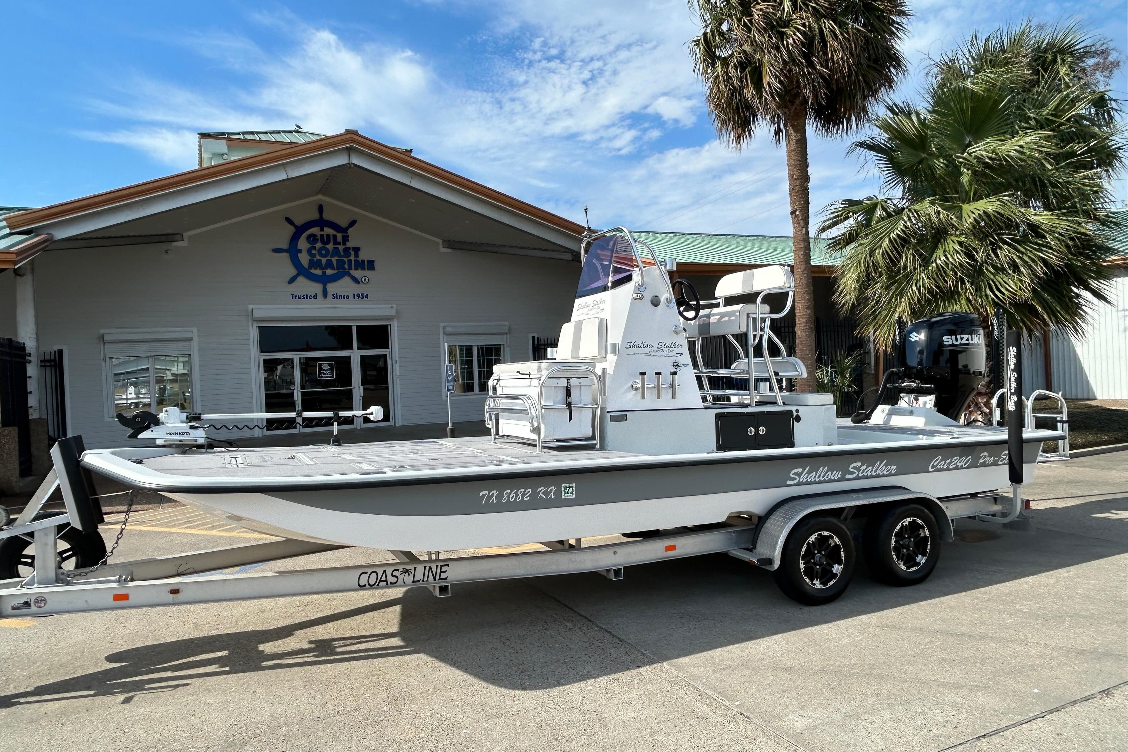 2023 Shallow Stalker Cat 240 Elite boat on trailer outside Gulf Coast Marine.