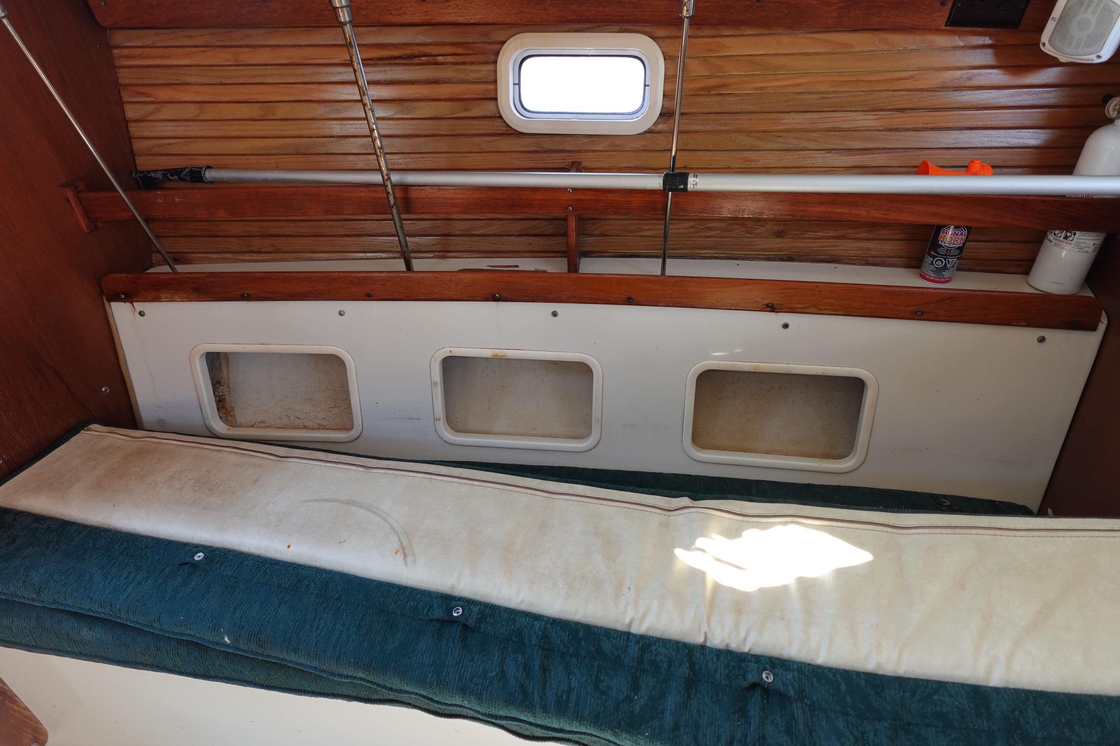 Interior of a 1997 Catalina 28 sailboat with wooden paneling and storage compartments.