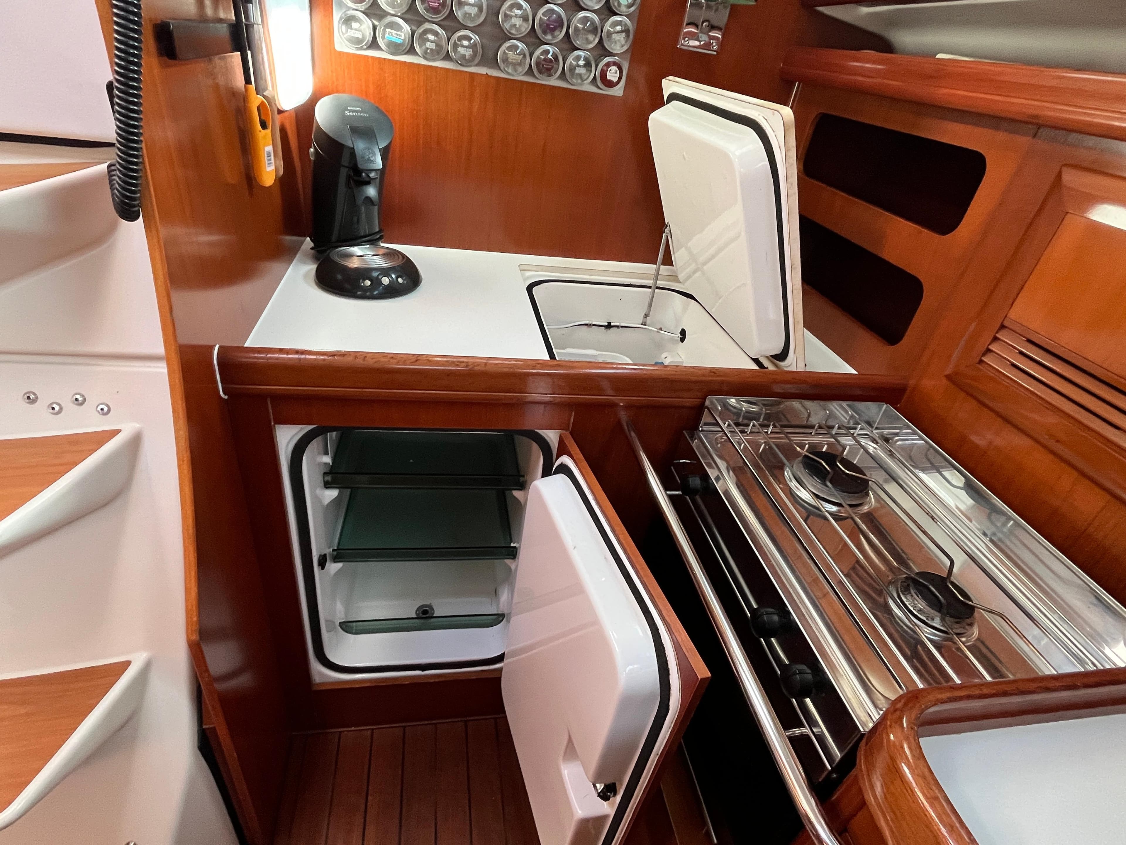 Beneteau Oceanis 393 yacht kitchen with stove, fridge, and wooden cabinetry, 2001 model.