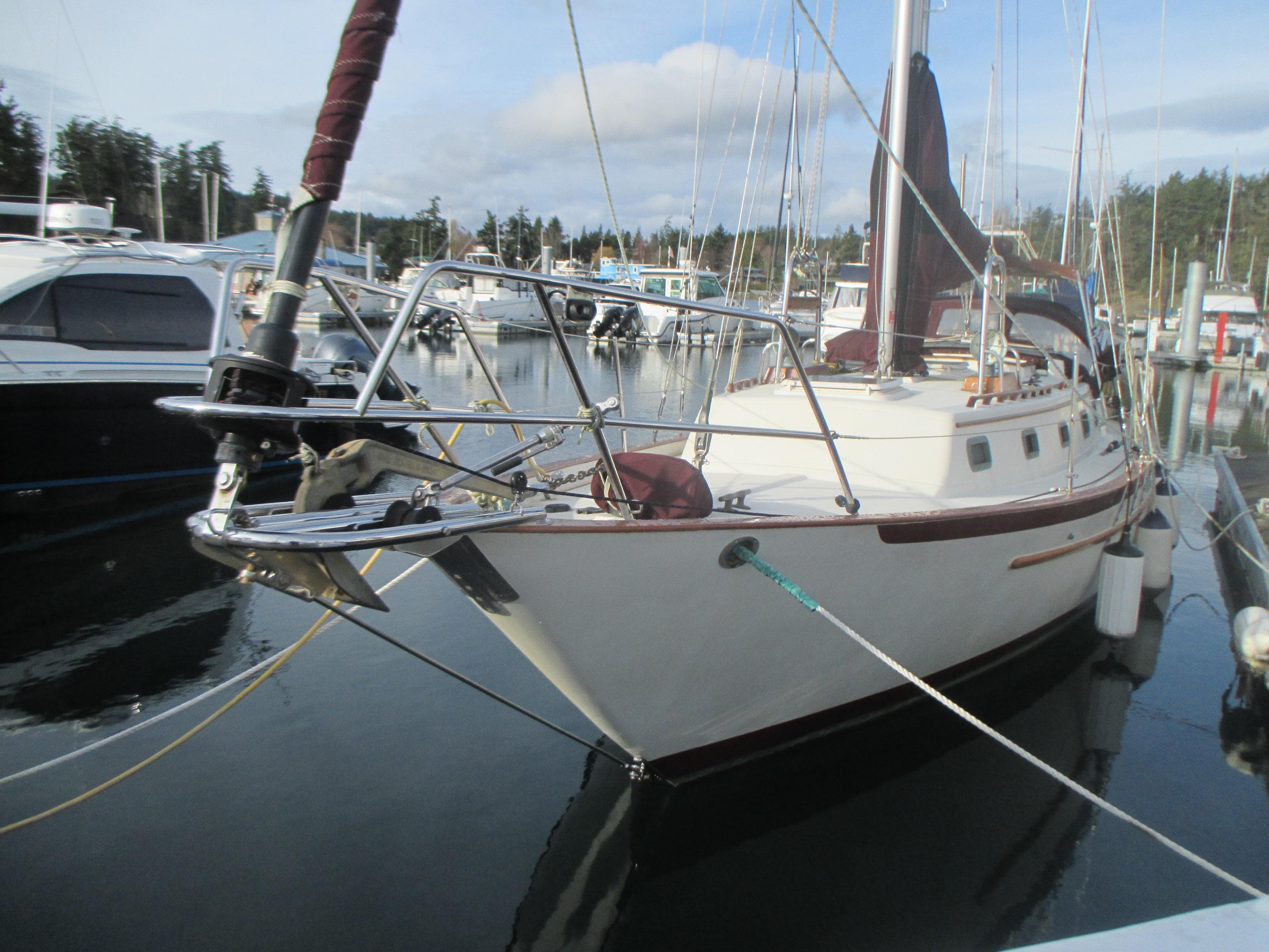 1990 Pacific Seacraft 37 sailboat docked in a marina, surrounded by other boats.