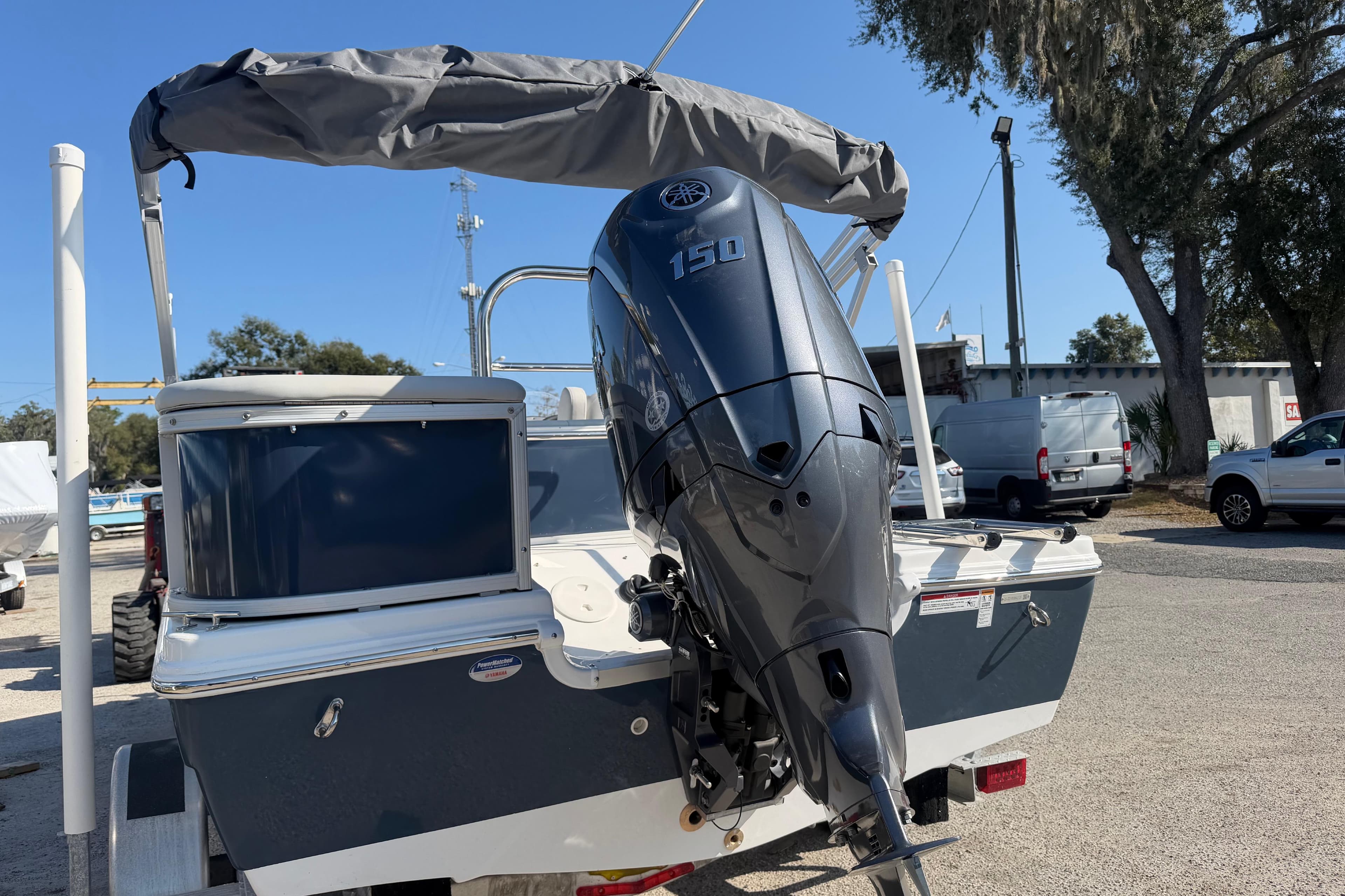2026 Hurricane FunDeck 198 RE OB boat with outboard motor, parked outdoors.