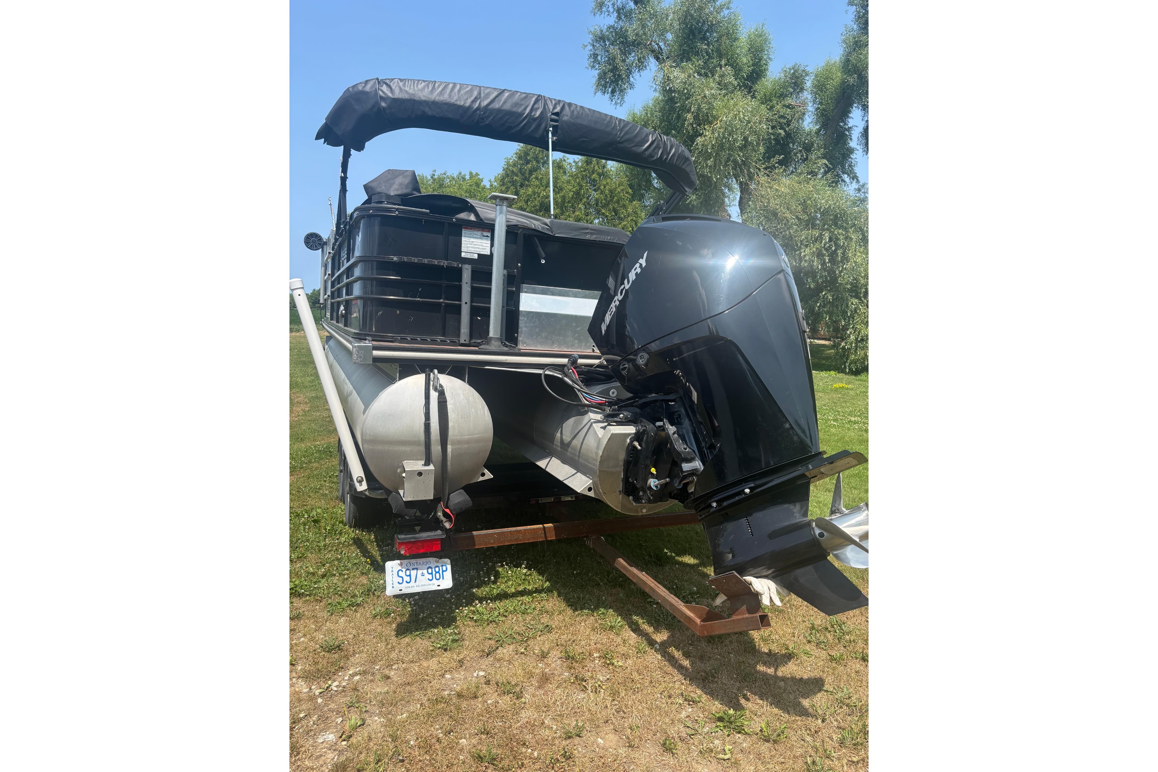 2016 Legend 25 boat with Mercury outboard motor on grassy area.