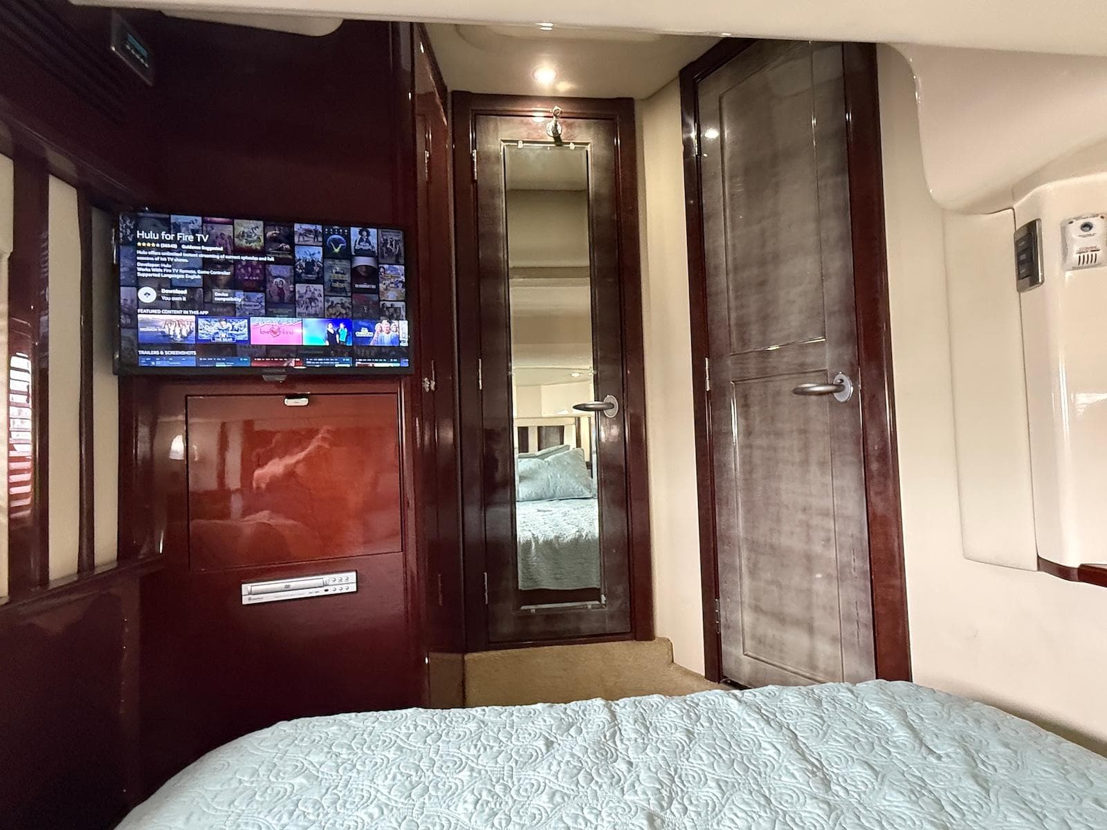 Interior of 2007 Sea Ray 52 Sedan Bridge with TV, mirror, and wooden cabinetry.