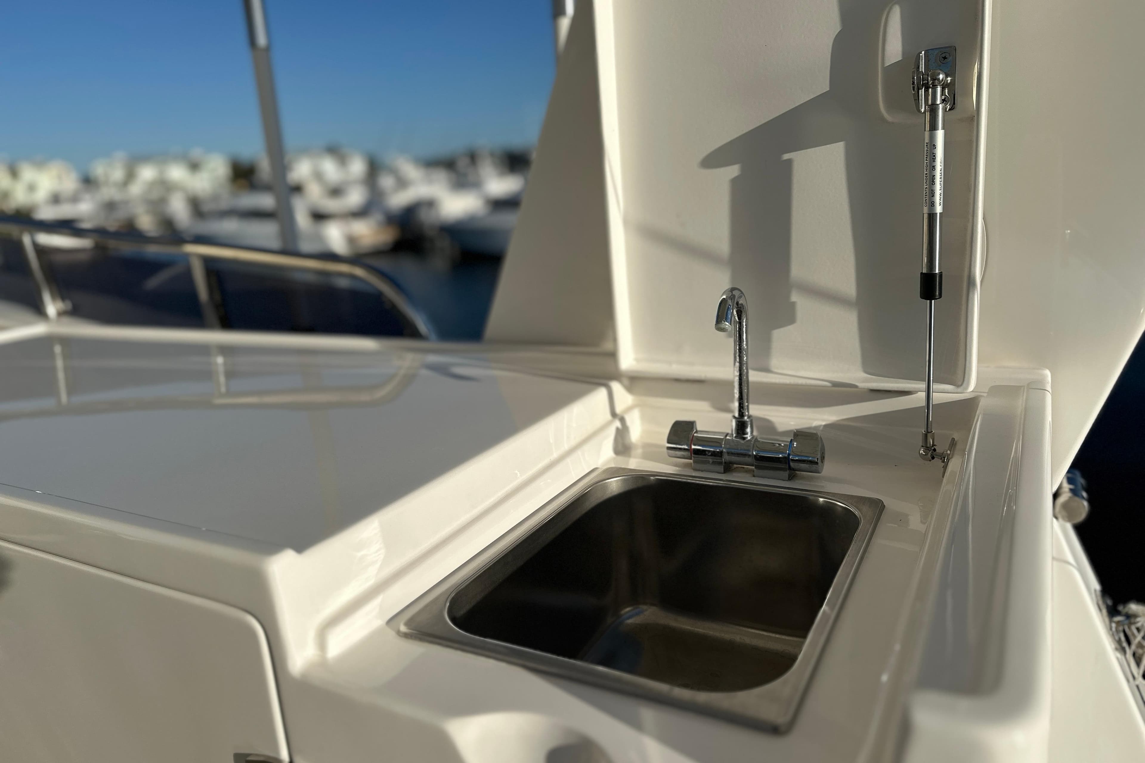 Outdoor sink on 2017 Kadey-Krogen 58EB yacht, with marina in background.