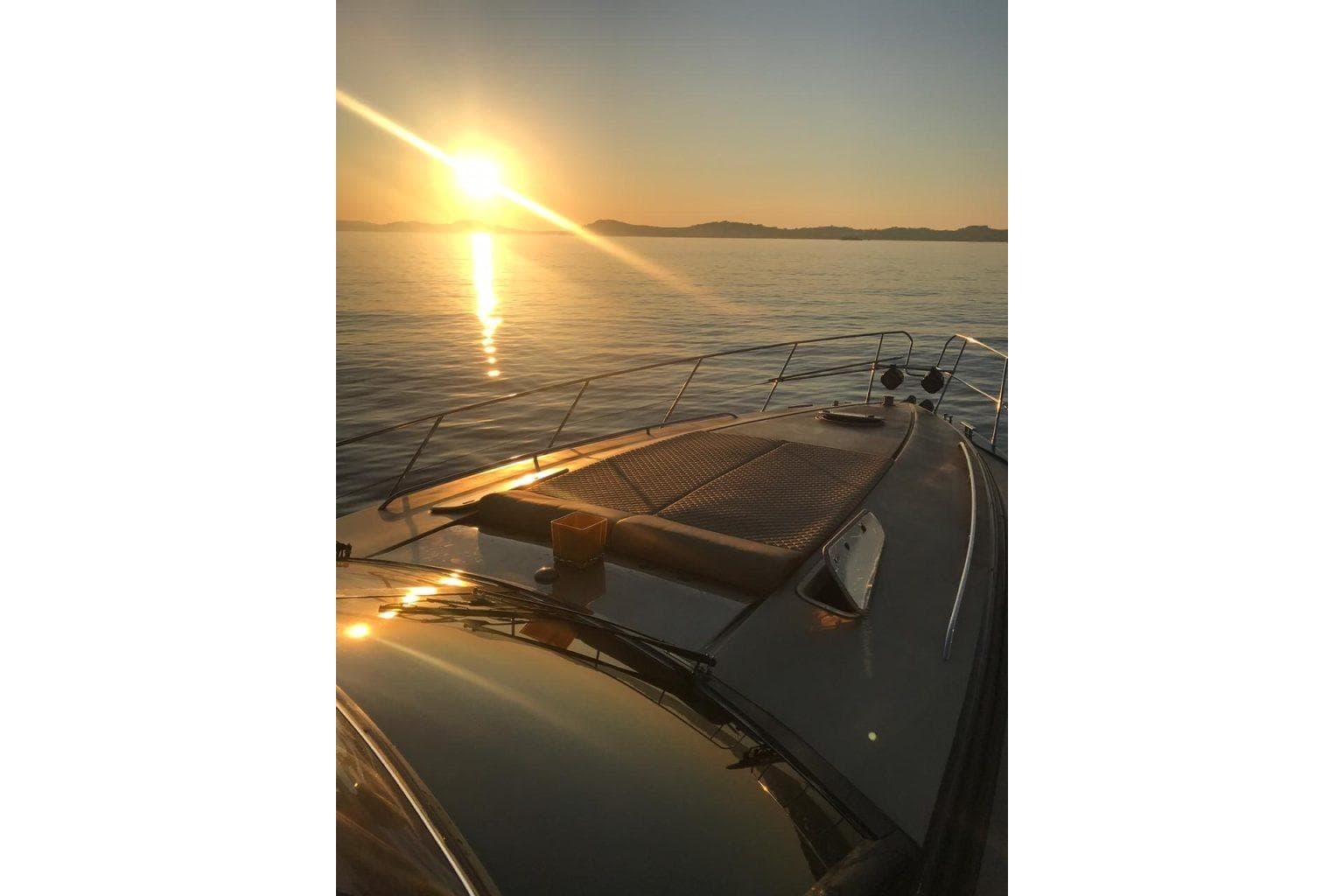 Sunset view from a 1996 Princess V52 yacht on calm waters.