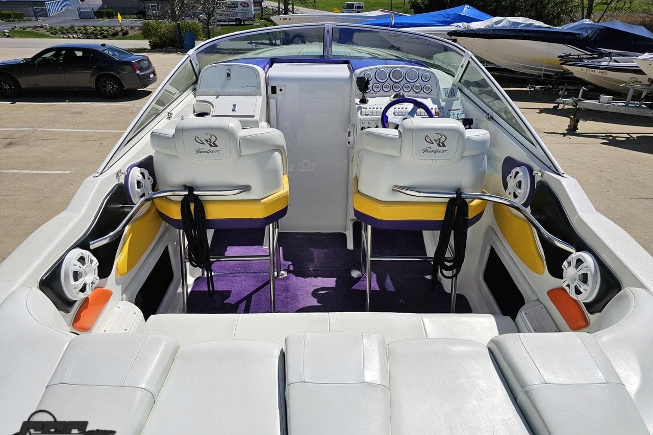 2001 Powerquest 340 Vyper boat interior with white seating, purple accents, and control panel.