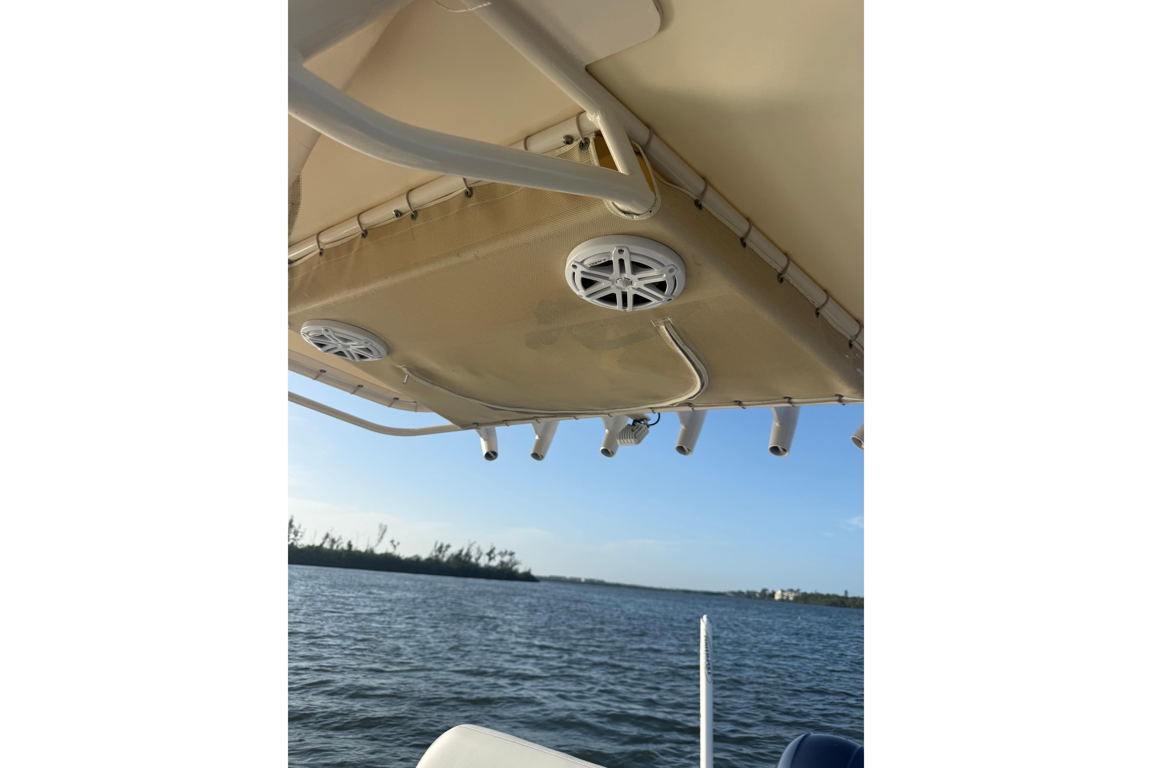 2017 Pathfinder 2200 TRS boat canopy with speakers, overlooking calm waters.
