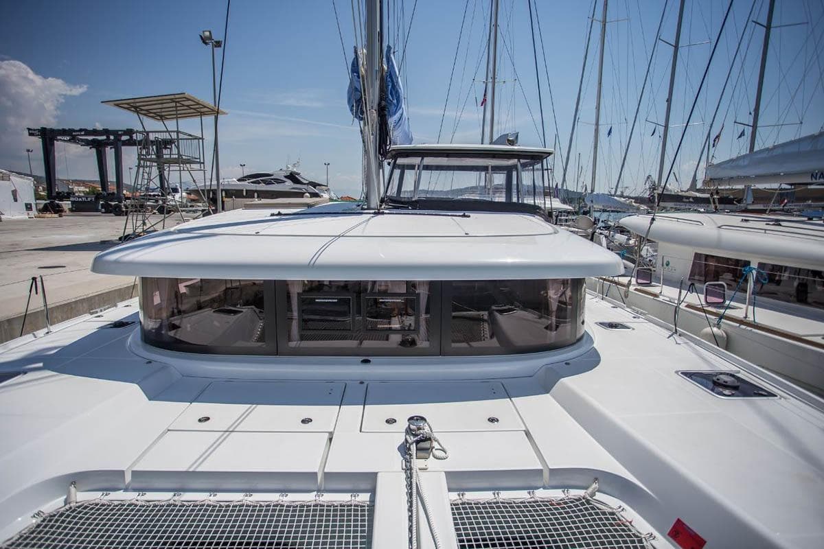 2019 Lagoon 42 catamaran docked at marina, showcasing sleek design and spacious deck.