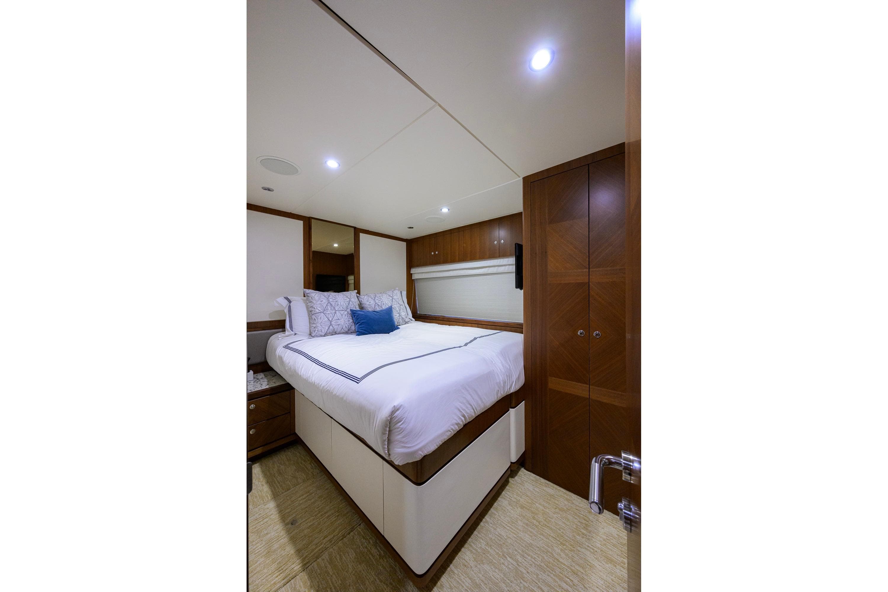 Luxurious bedroom interior of 2017 Ocean Alexander 100 Motoryacht with elegant wood finishes.