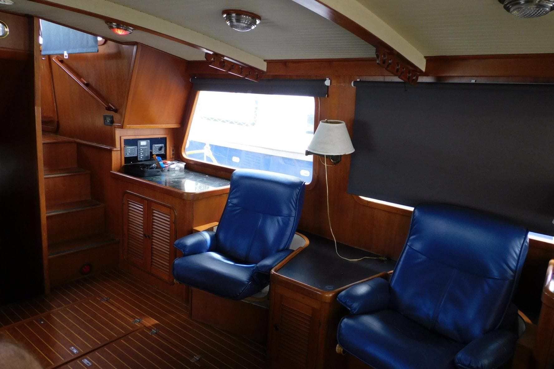 Interior of 1988 Hans Christian 45 Independence Trawler with blue leather chairs and wooden accents.