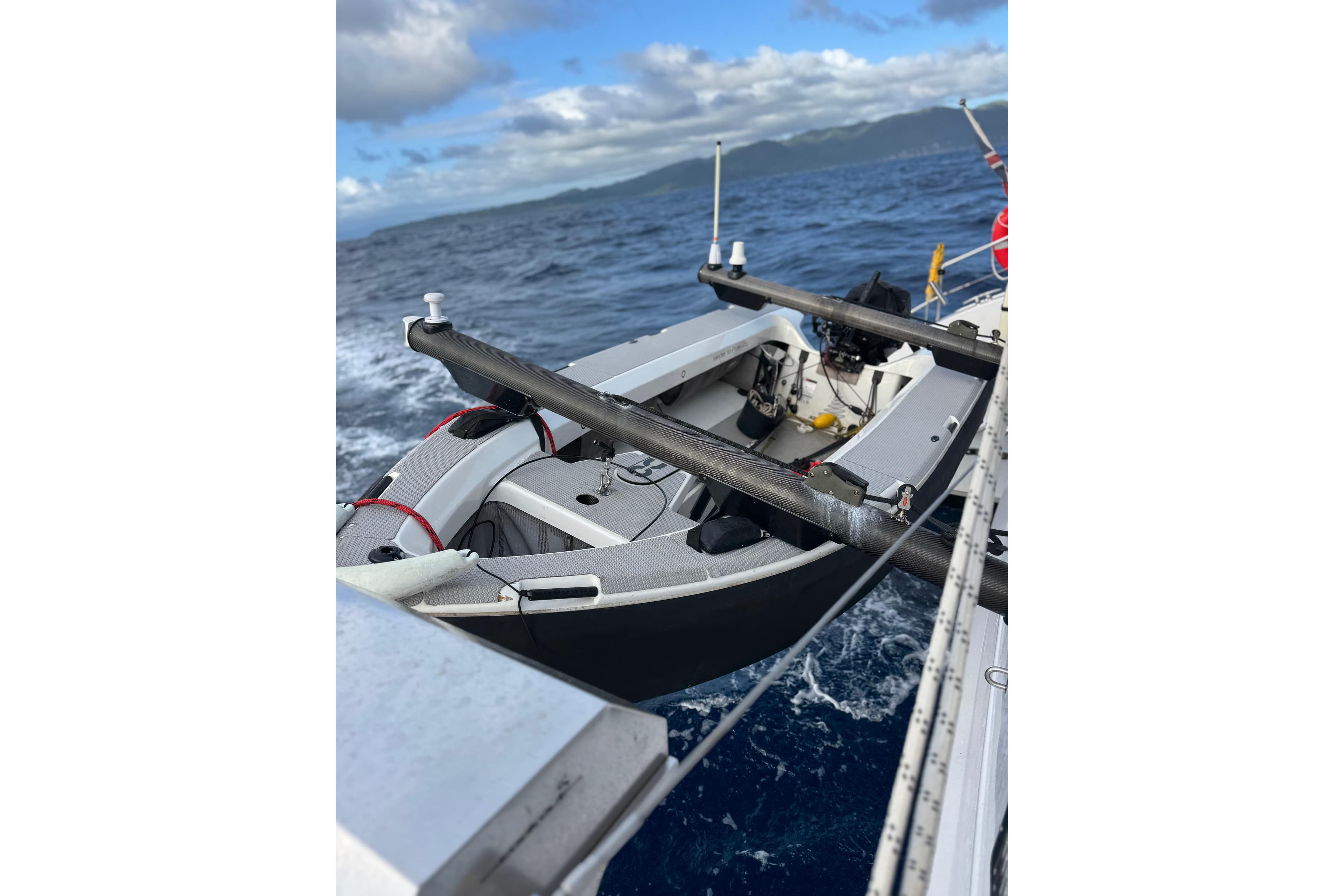 2023 Seawind 1600 sailboat navigating ocean waves under cloudy skies.