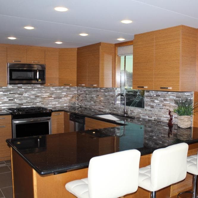 Modern kitchen with wooden cabinets, black granite countertops, and stainless steel appliances in Bravada Evolution Share #7, 2015.
