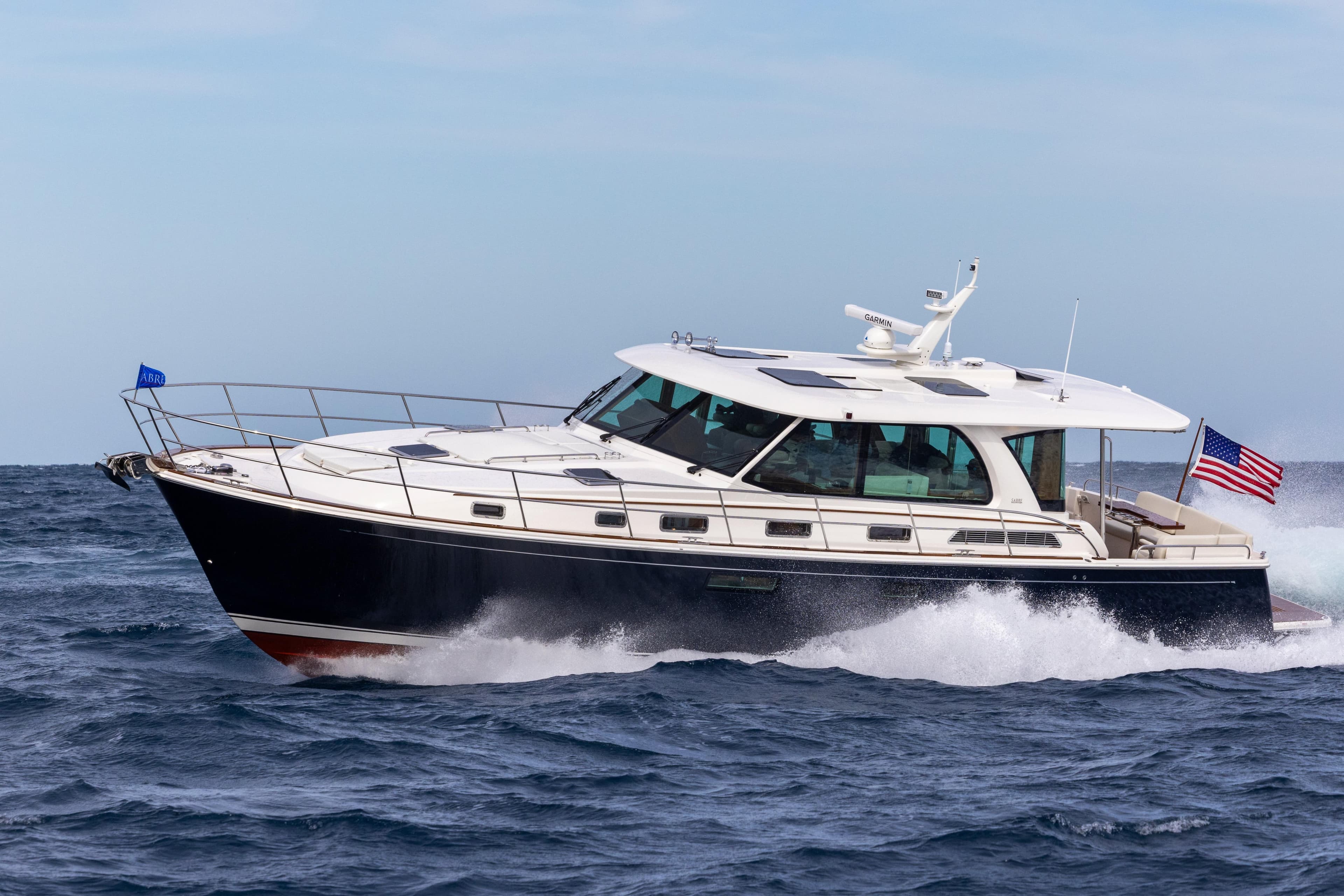 2026 Sabre 51 Salon Express yacht cruising on open water with American flag.