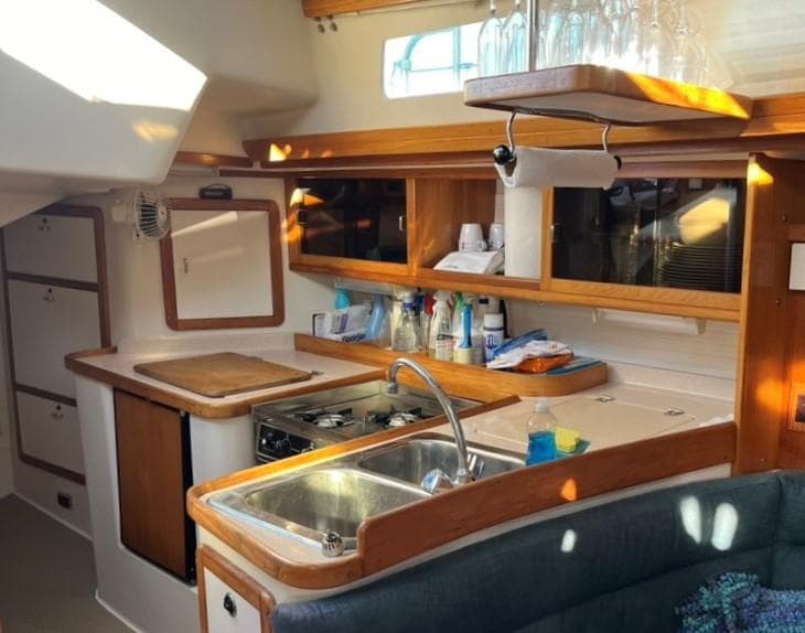 Interior of 1998 Catalina 42 Mk II sailboat, featuring a well-equipped kitchen with wooden cabinetry.
