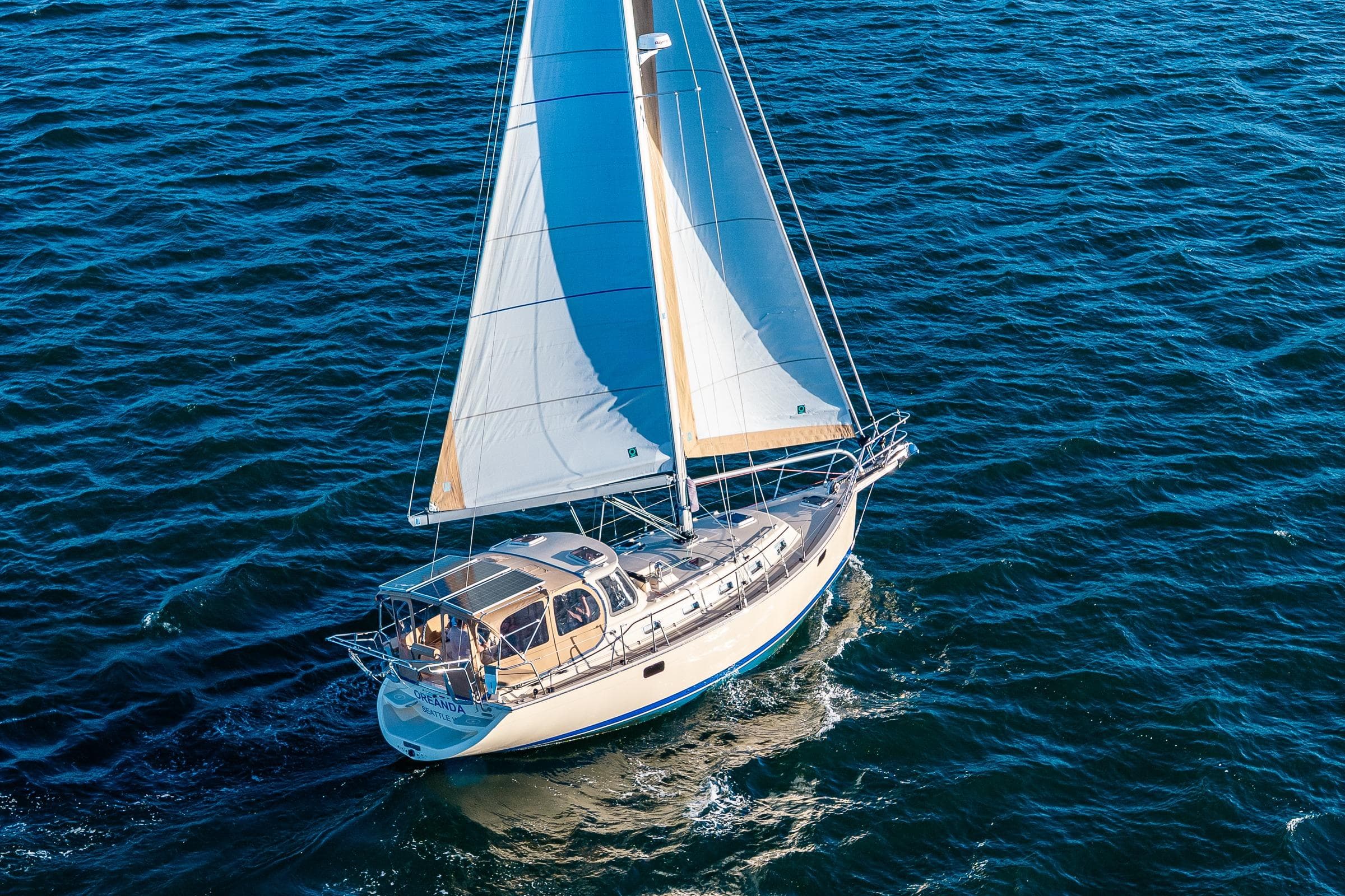 2020 Island Packet 349 sailboat navigating blue ocean waters.