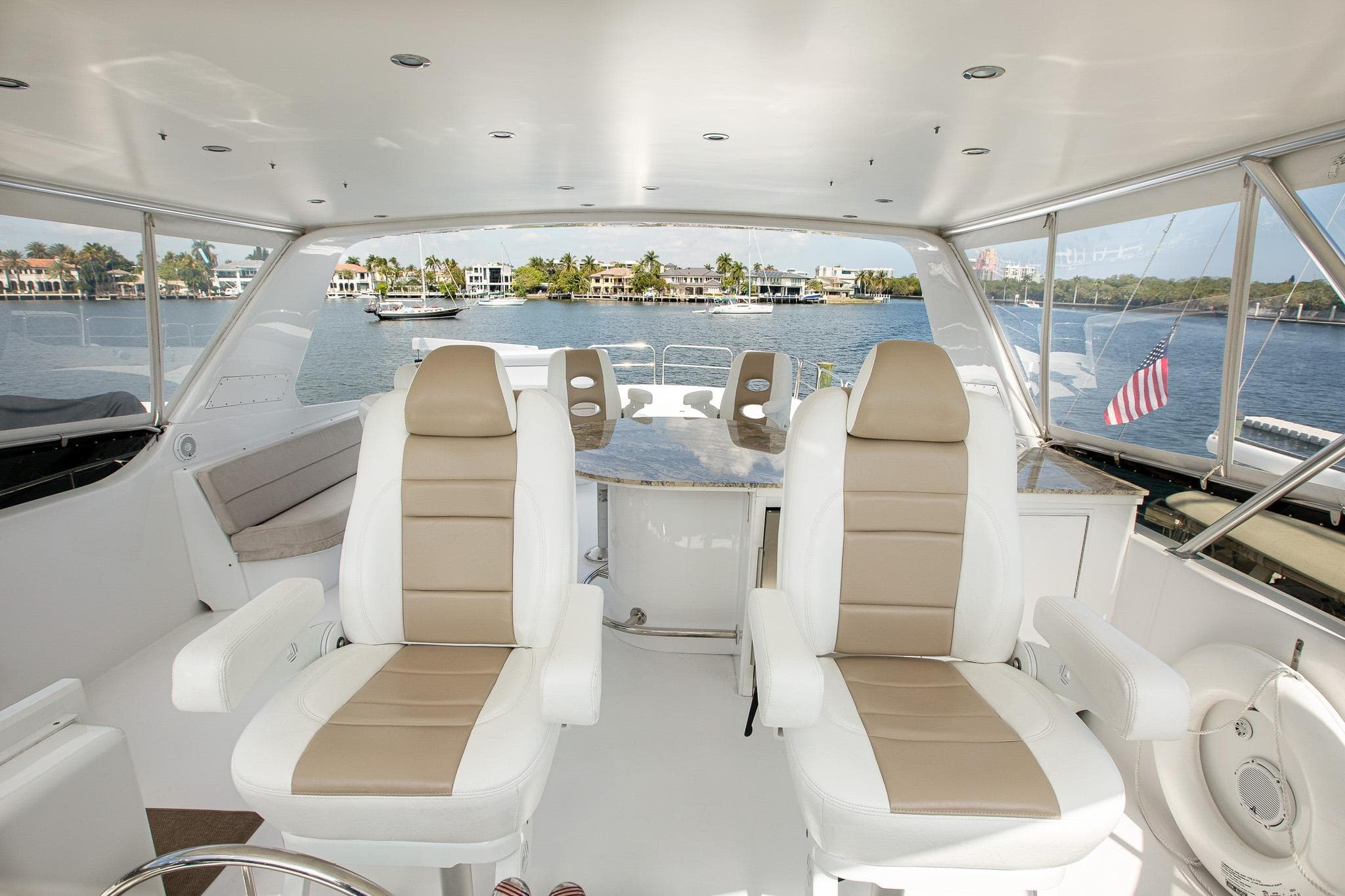 Luxurious 2001 Hatteras 75 Cockpit Motor Yacht interior with scenic waterfront view.