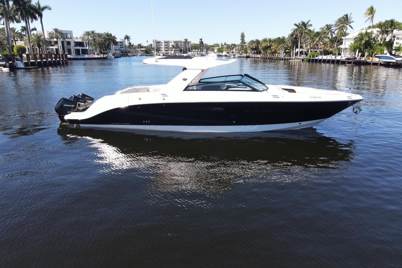 2022 Sea Ray SLX 400 Outboard boat on a calm waterway, surrounded by palm trees.