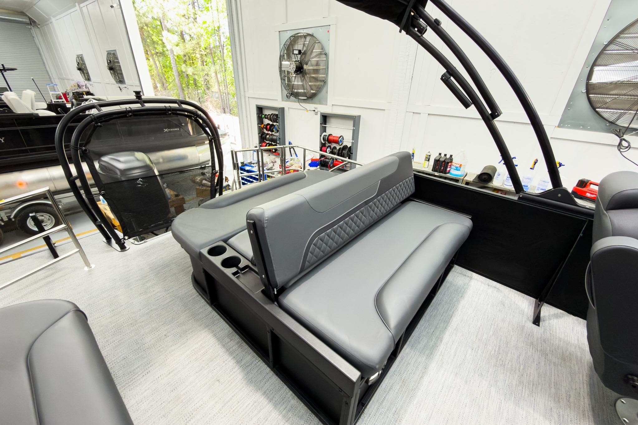 2026 Godfrey Sweetwater 22' Tritoon with sleek lounge seating in a modern showroom.