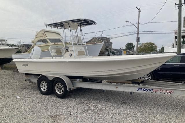 2023 Bulls Bay 2400 boat on trailer, parked in a gravel lot.