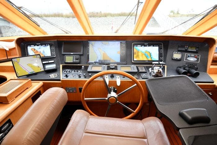 Pilothouse interior of 2001 Symbol Raised Pilothouse Motoryacht with navigation equipment and steering wheel.