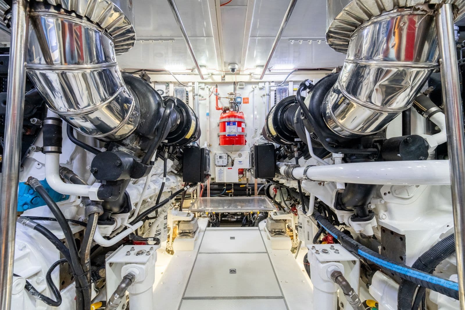 Engine room of 2013 Horizon E88 yacht with shiny exhaust pipes.