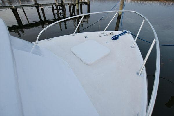 1965 Bertram Sportfisher boat deck with railing and dock view.